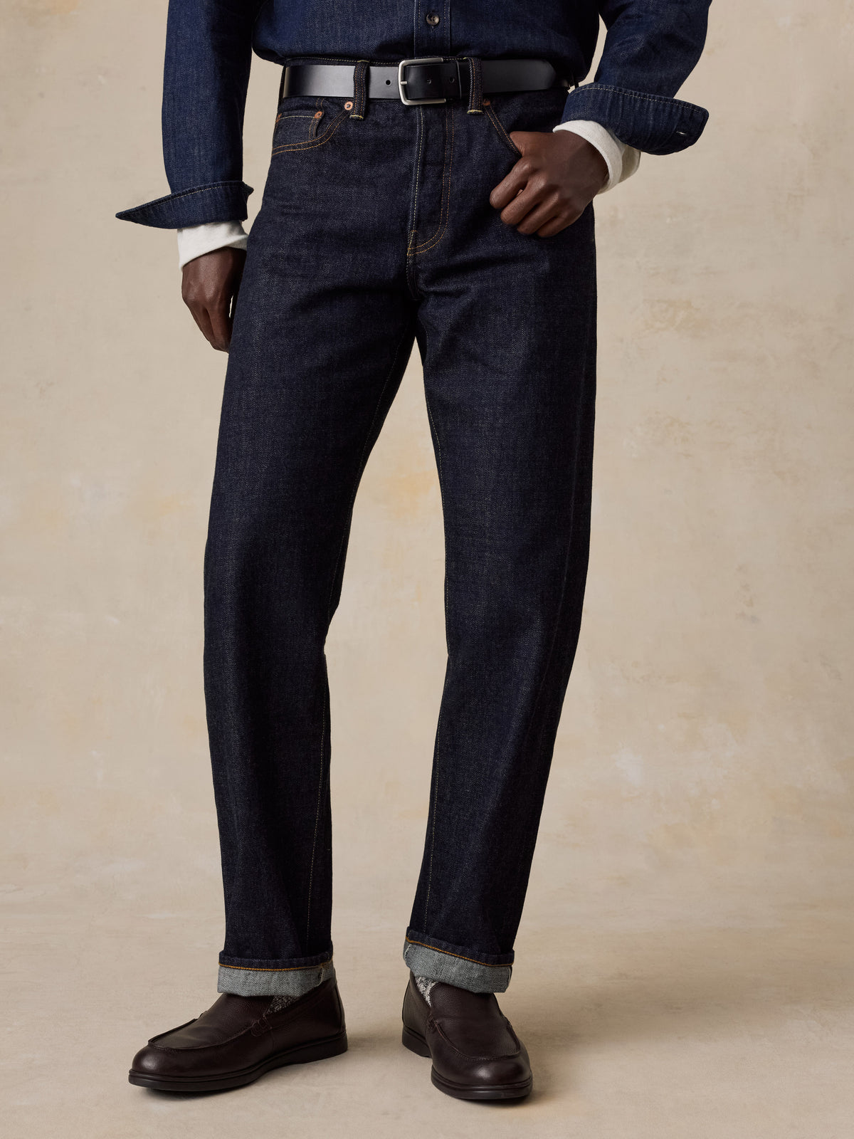 A man wearing blue selvedge denim pants and a blue denim shirt, image 2 of 6