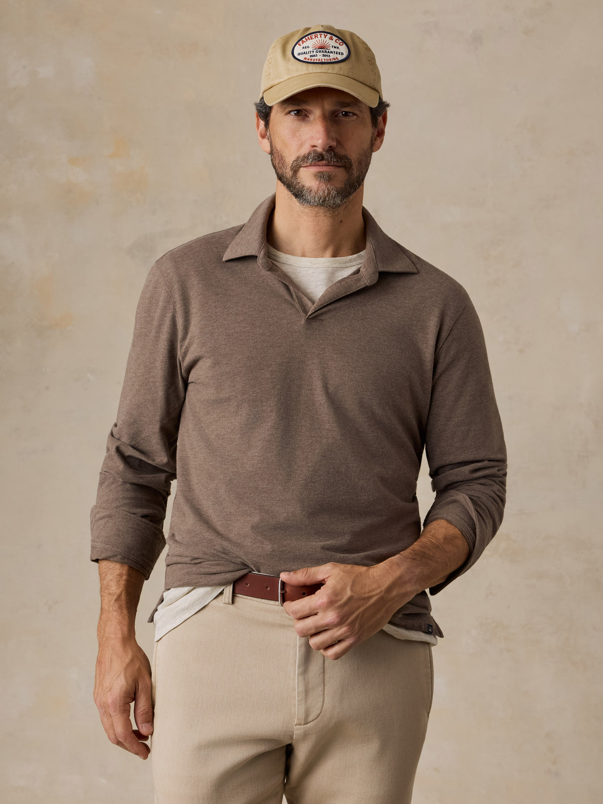 A man wearing a brown polo shirt and beige chino pants, image 1 of 6