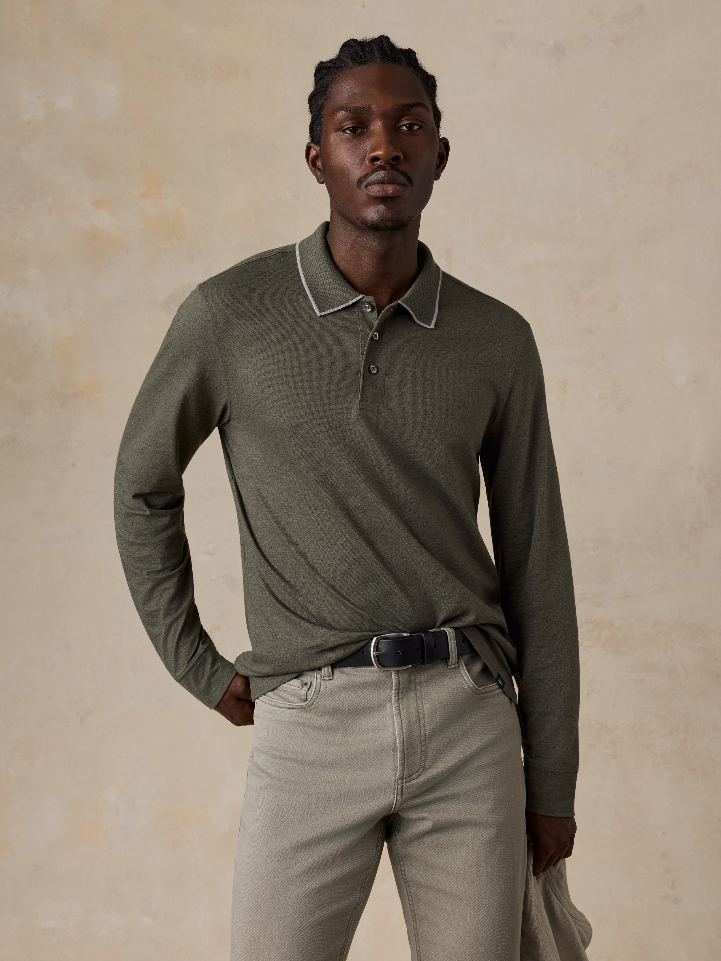 A man wearing a green long sleeve polo with green pants