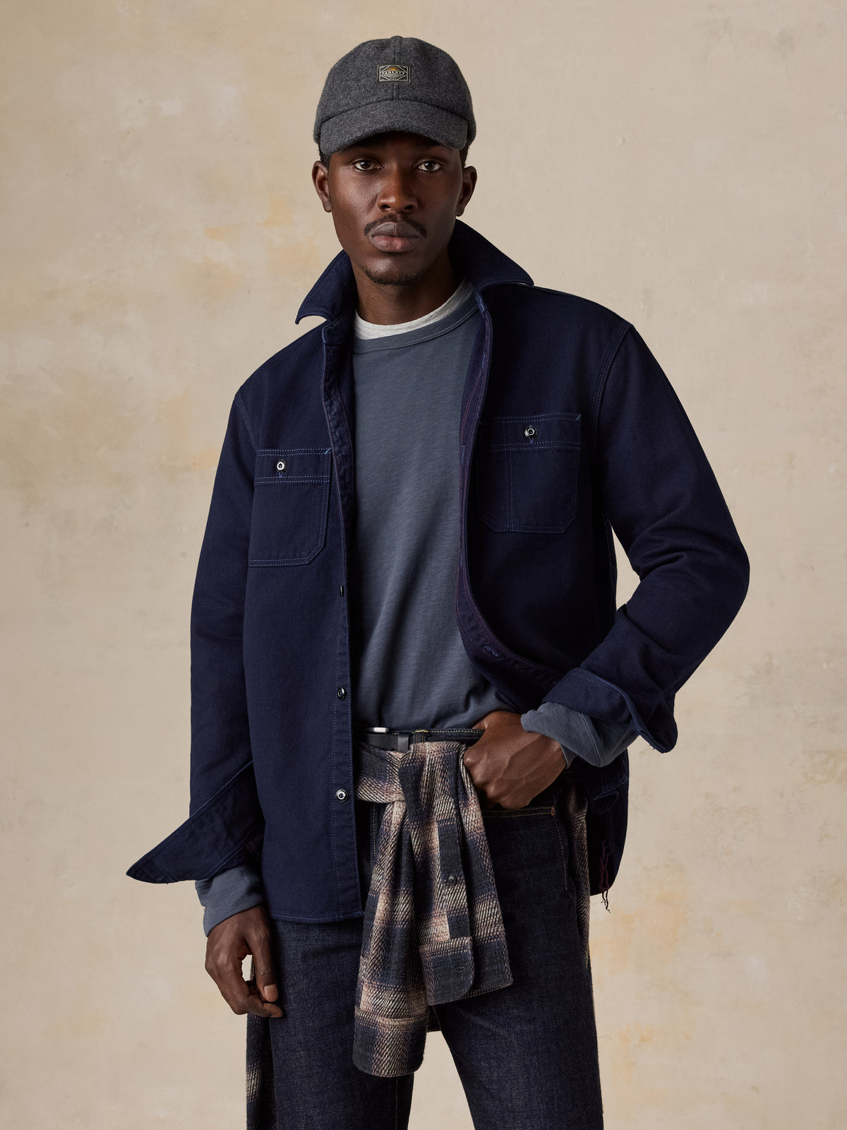 A man wearing a blue workshirt over a blue tee and blue jeans, image 4 of 6
