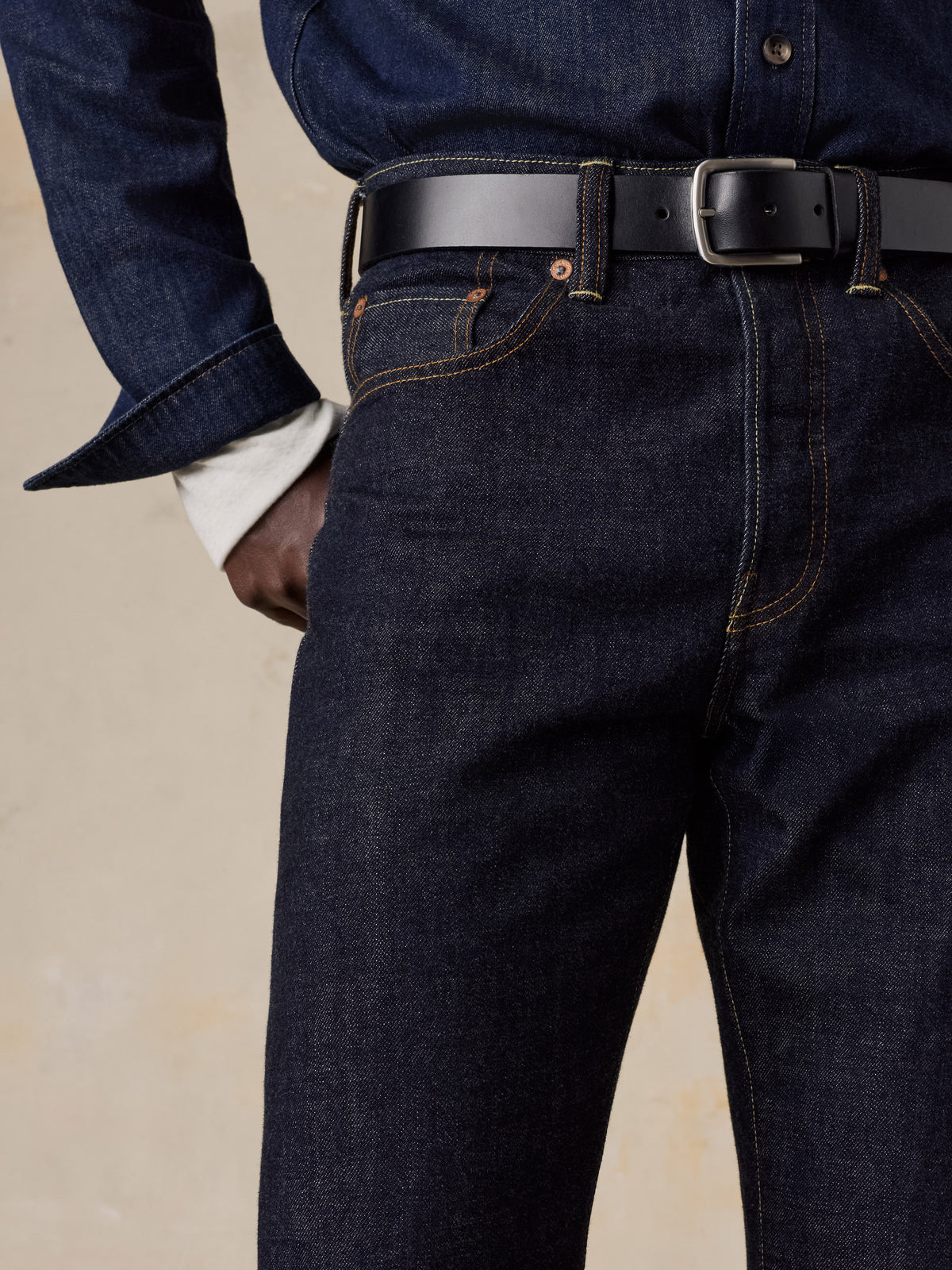 Close up of a man wearing blue selvedge denim pants and a blue denim shirt, image 5 of 6