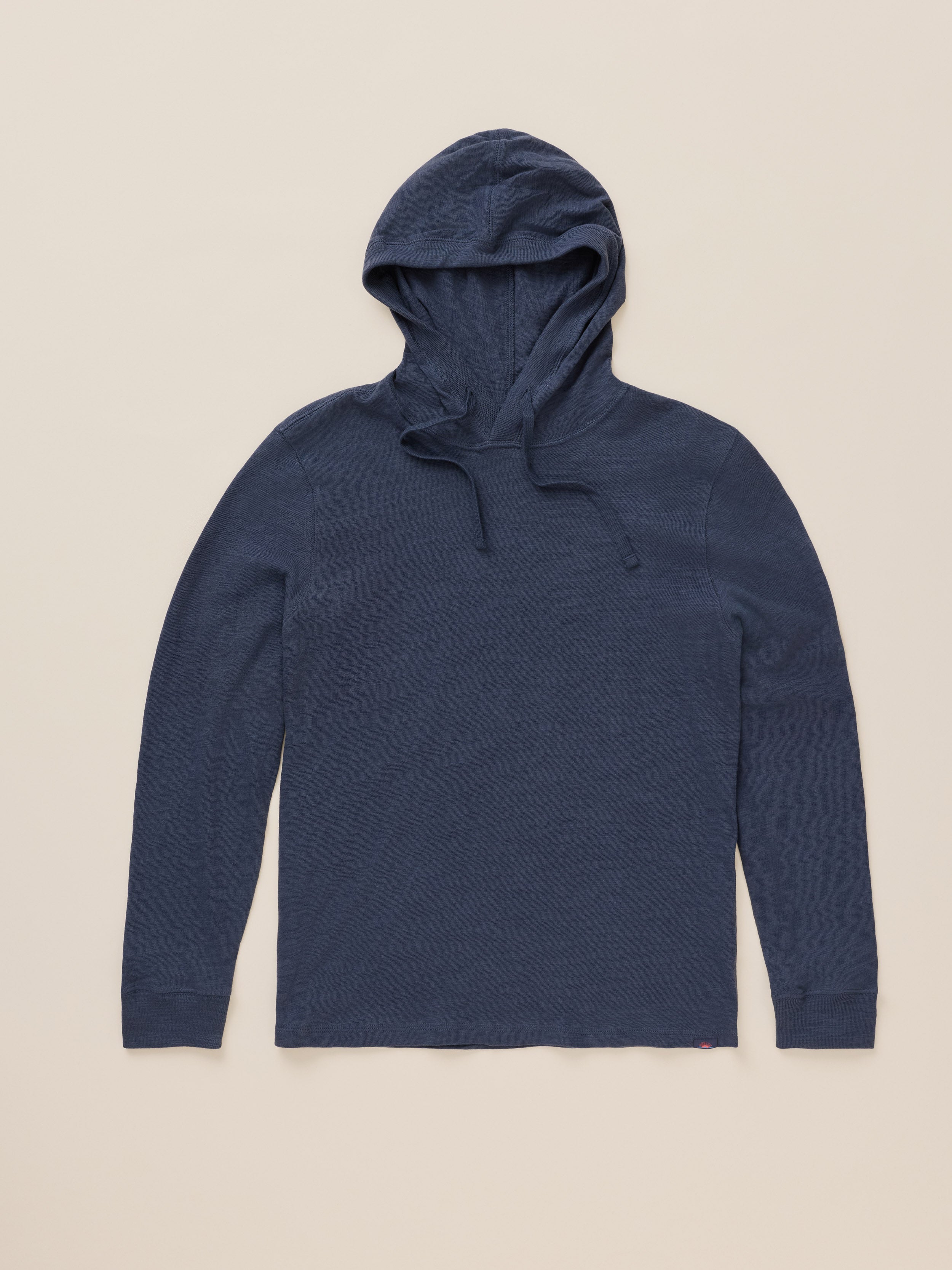 A navy blue long-sleeve hooded shirt with drawstrings, laid flat against a light beige background.