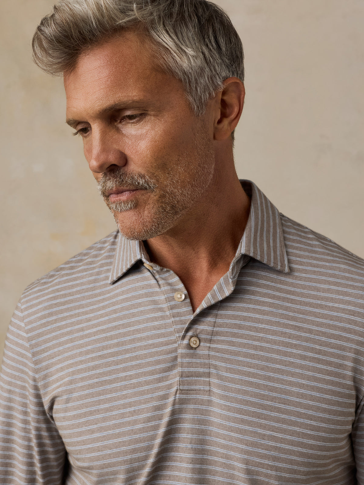 Close up of a man wearing a long-sleeve collared polo shirt, image 6 of 6