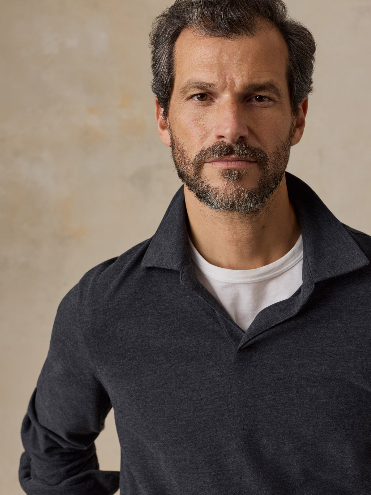 Close up of a man wearing a dark grey sweater polo, image 3 of 6