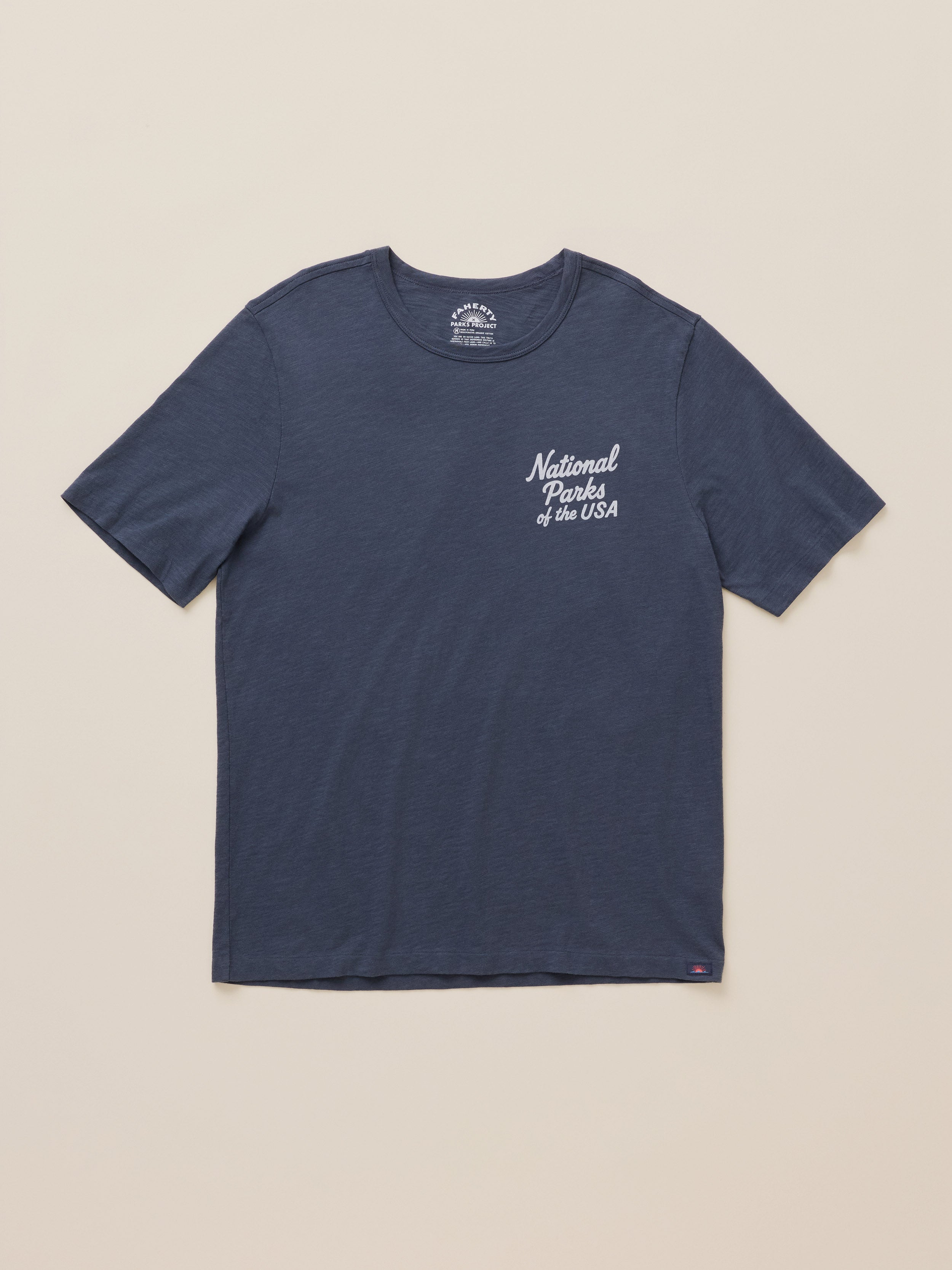 A navy blue short-sleeve crewneck t-shirt with 'National Parks of the USA' printed in white script on the left chest, displayed flat against a light beige background.