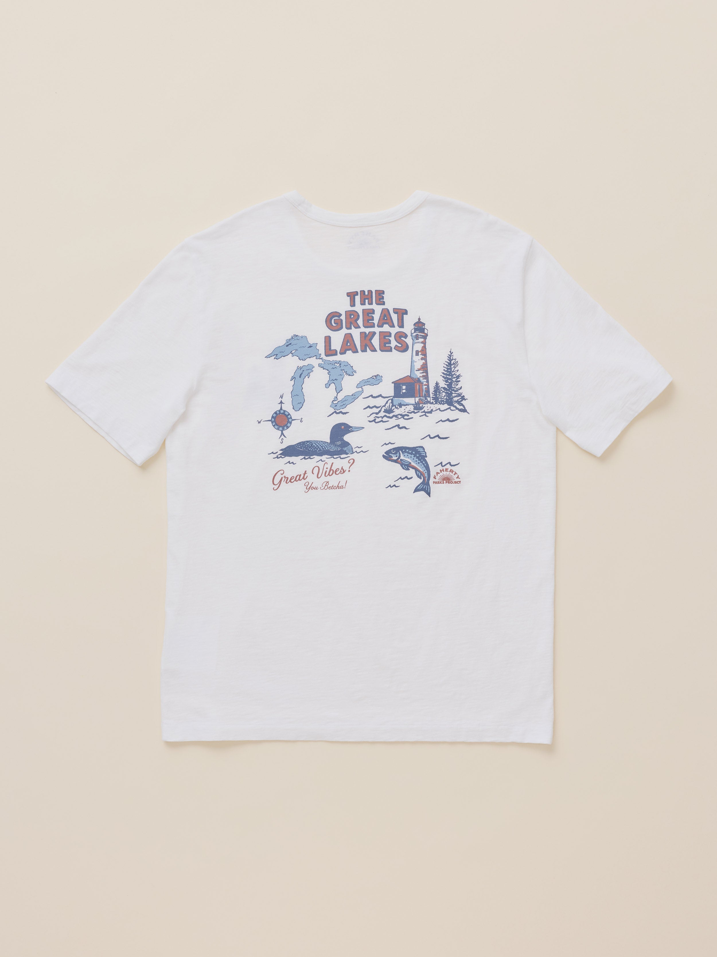 A white short-sleeve t-shirt with a 'The Great Lakes' graphic printed on the back, featuring illustrations of a lighthouse, ducks, and waterways, displayed flat against a light beige background.