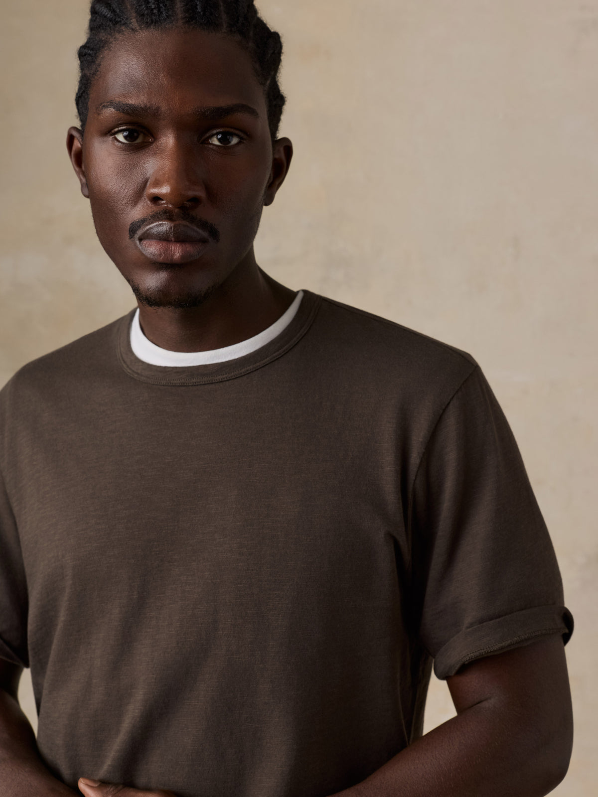 Close up of a man wearing a brown t-shirt, image 3 of 6