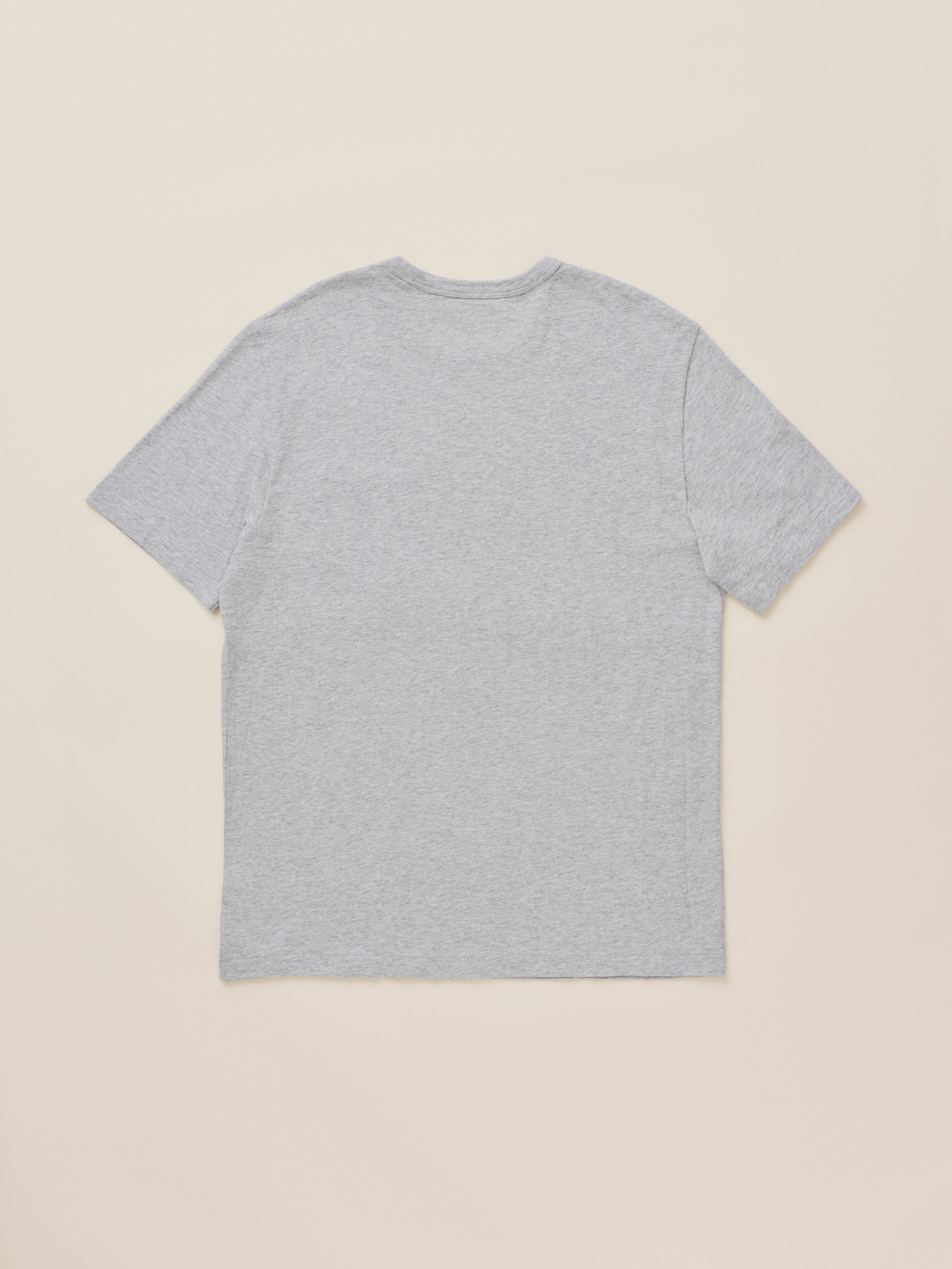 A light gray heather short-sleeve t-shirt shown from the back, laid flat against a solid beige background.