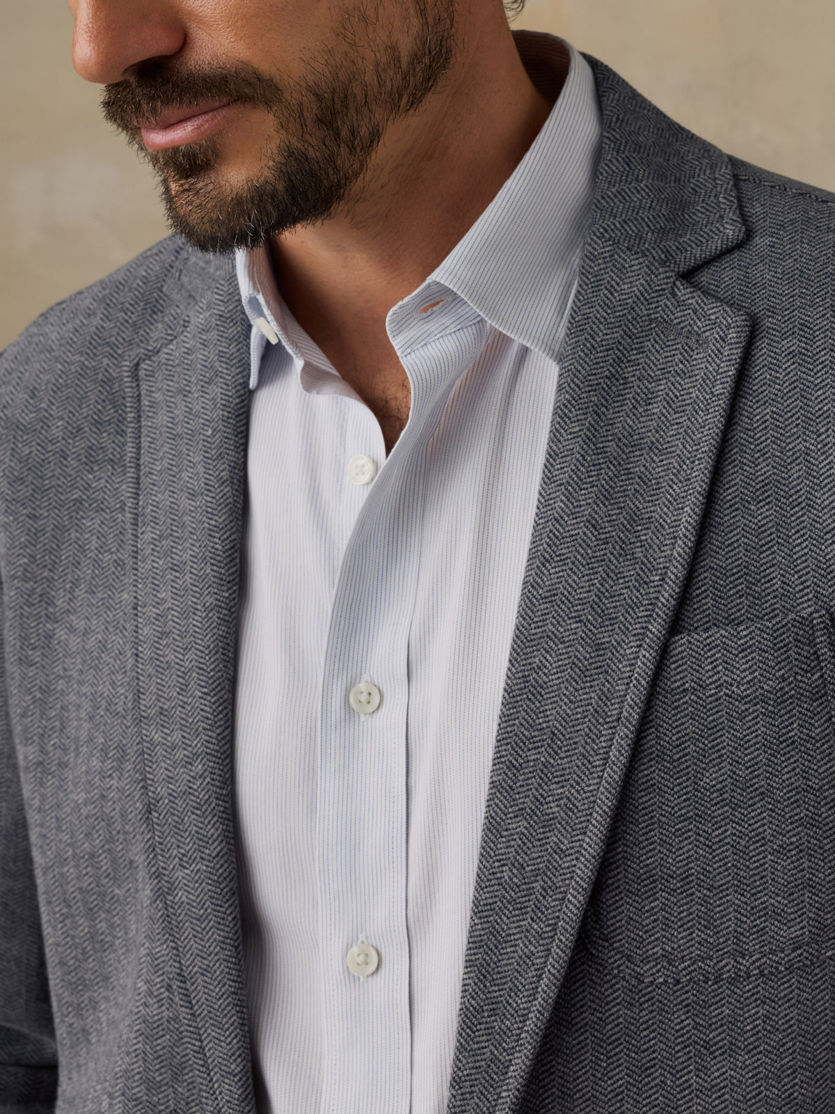 Close-up of a man wearing a gray tweed blazer over a white button-down dress shirt., image 7 of 7