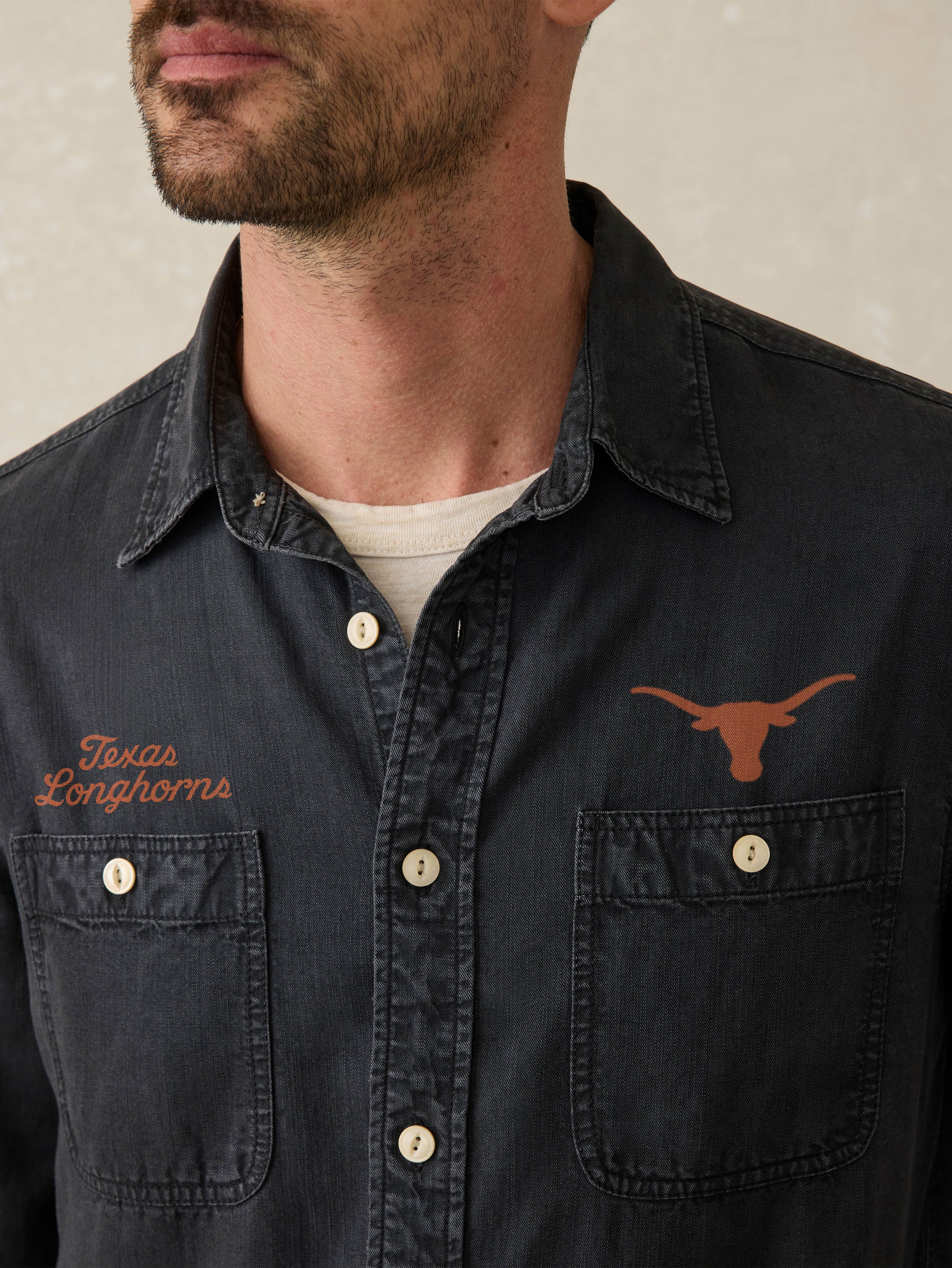 Man wearing a navy blue shirt with Texas Longhorns logo and text.