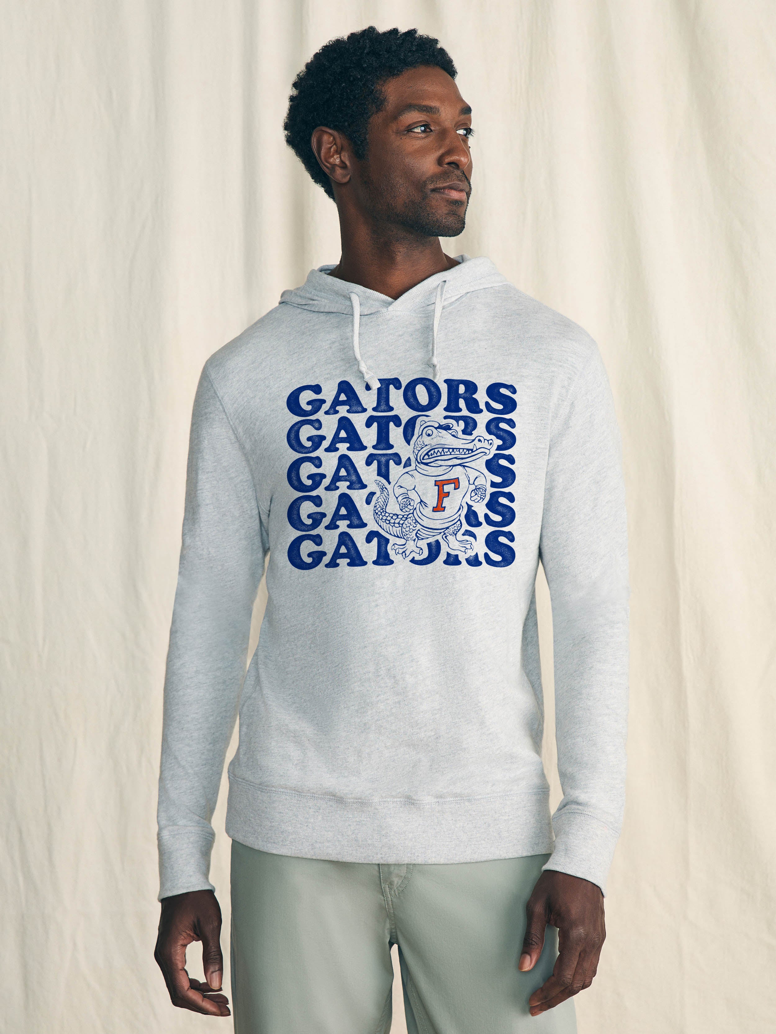 Man wearing a gray hoodie with 'Gators' text and logo on a plain background
