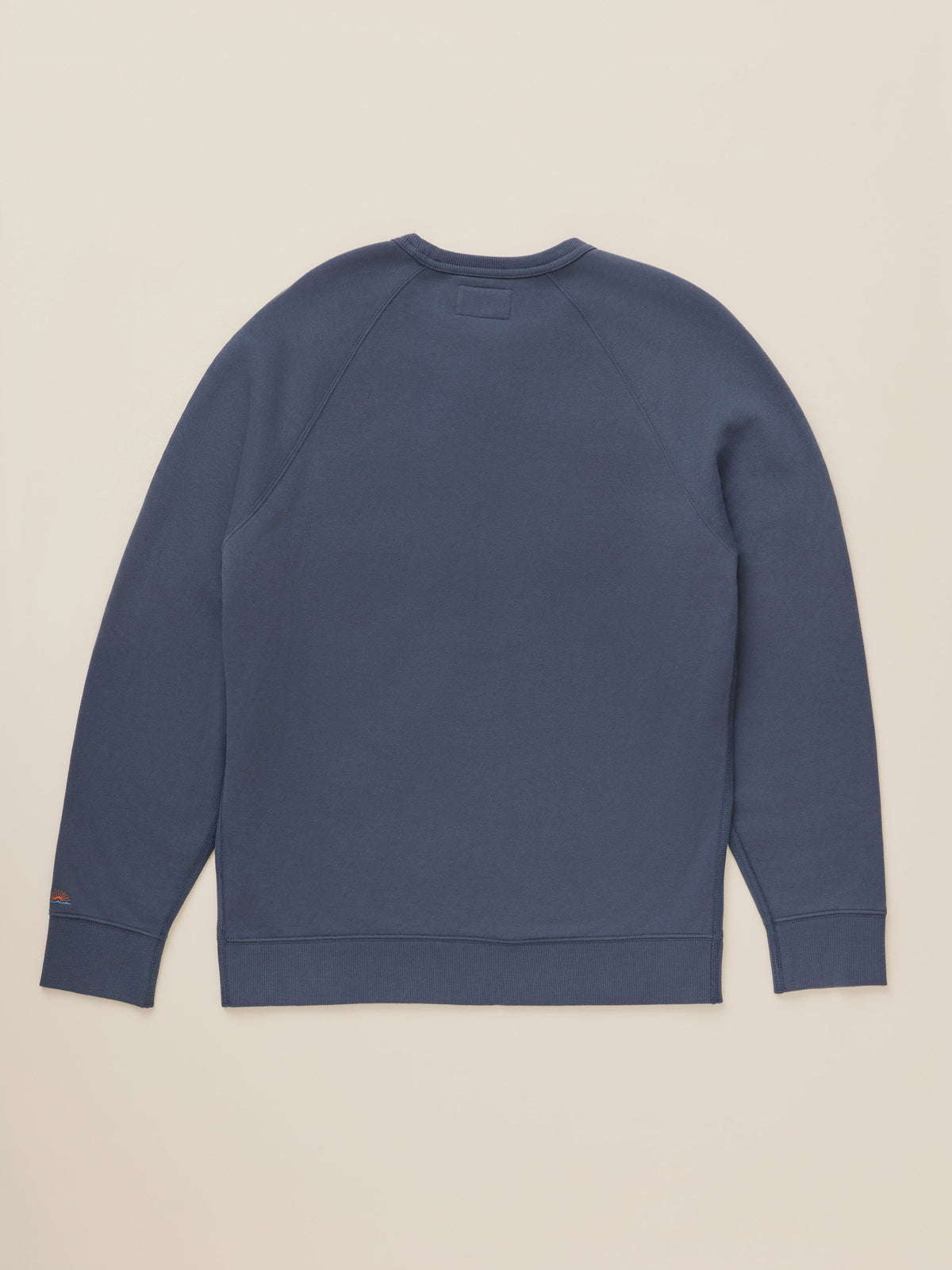 A slate blue crewneck sweatshirt shown from the back, laid flat against a light beige background., image 2 of 2
