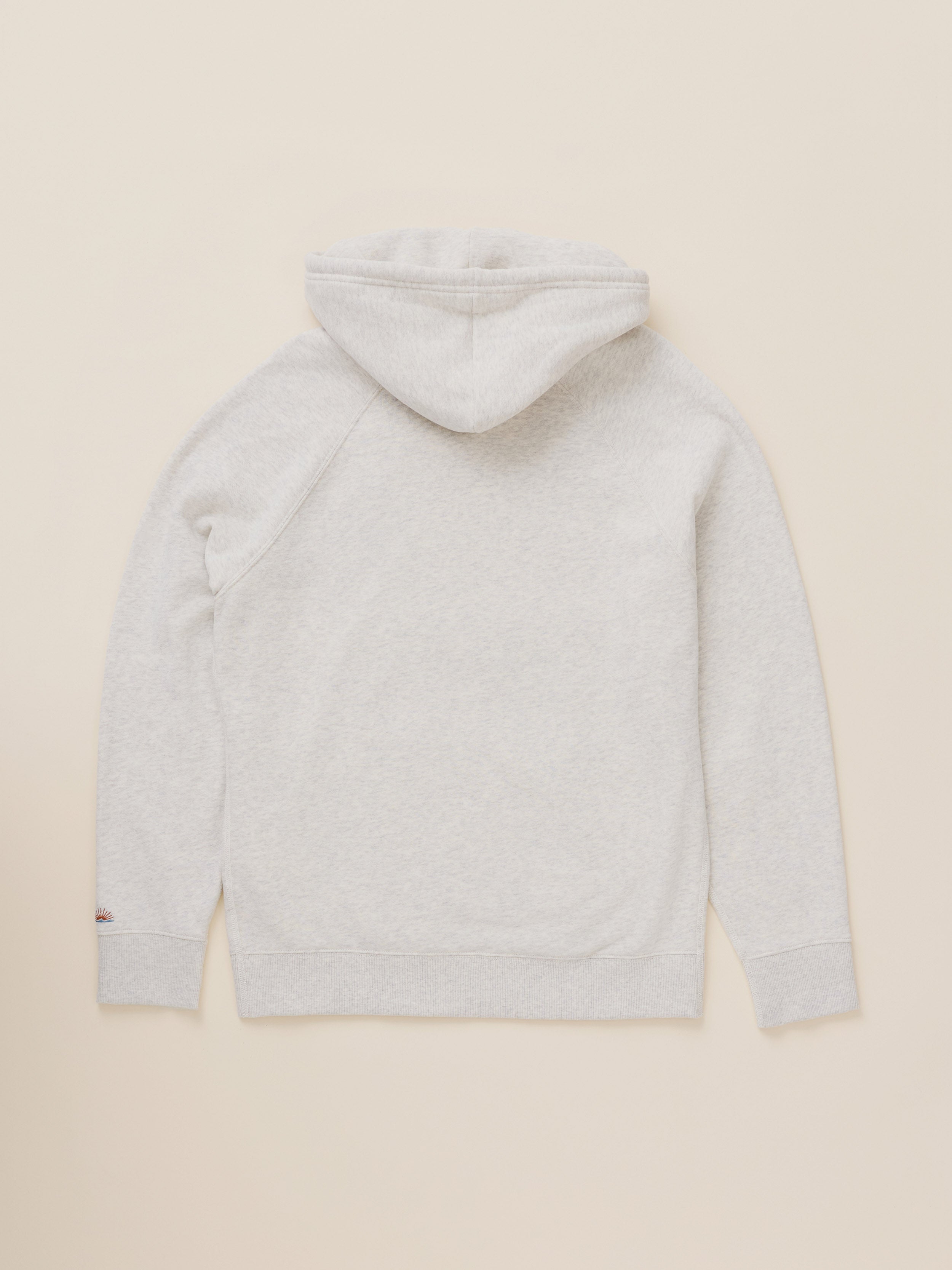 A light heather gray hooded sweatshirt shown from the back, laid flat against a solid cream-colored background.