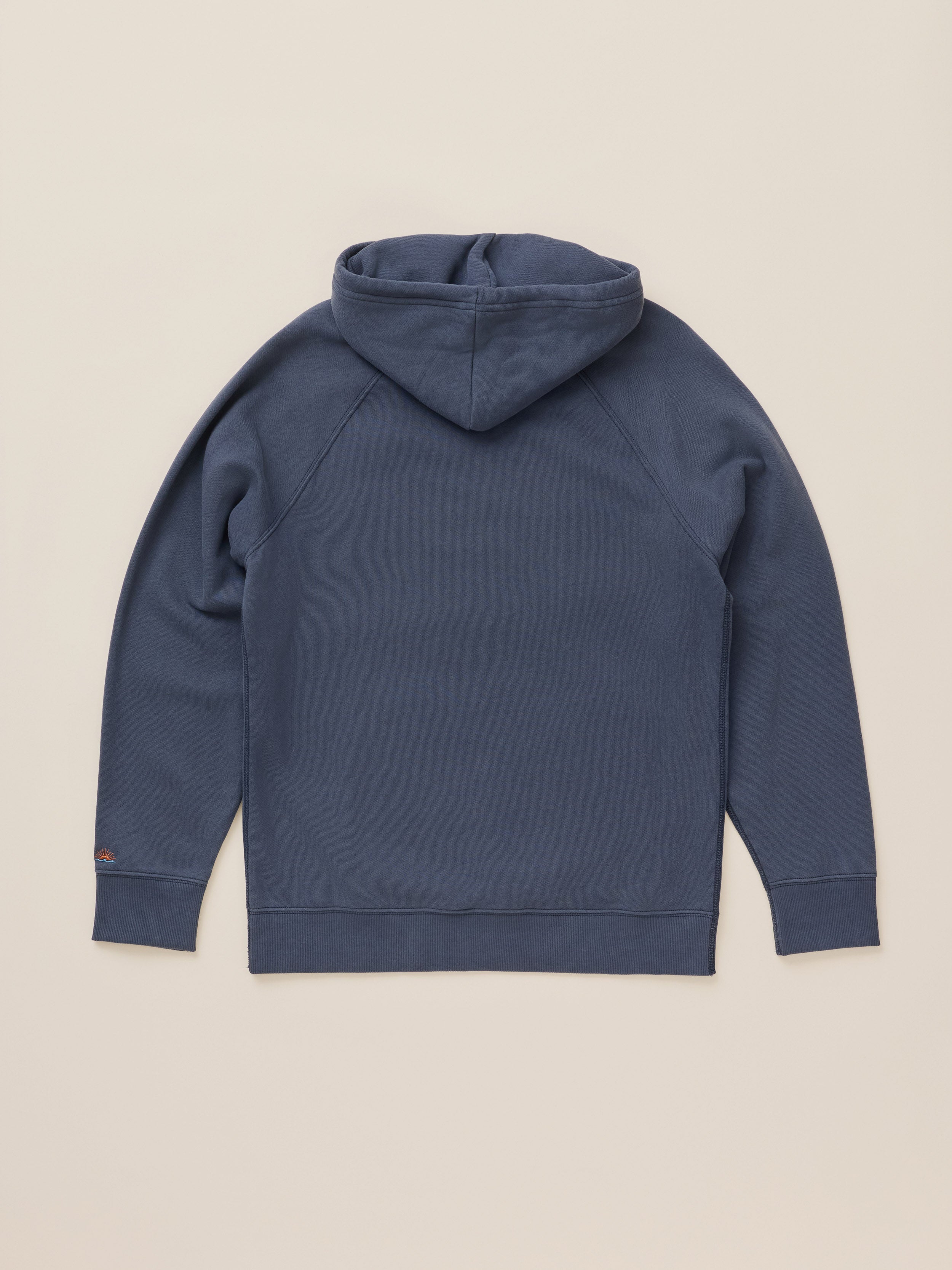 A navy blue pullover hoodie shown from the back, laid flat against a solid light beige background.