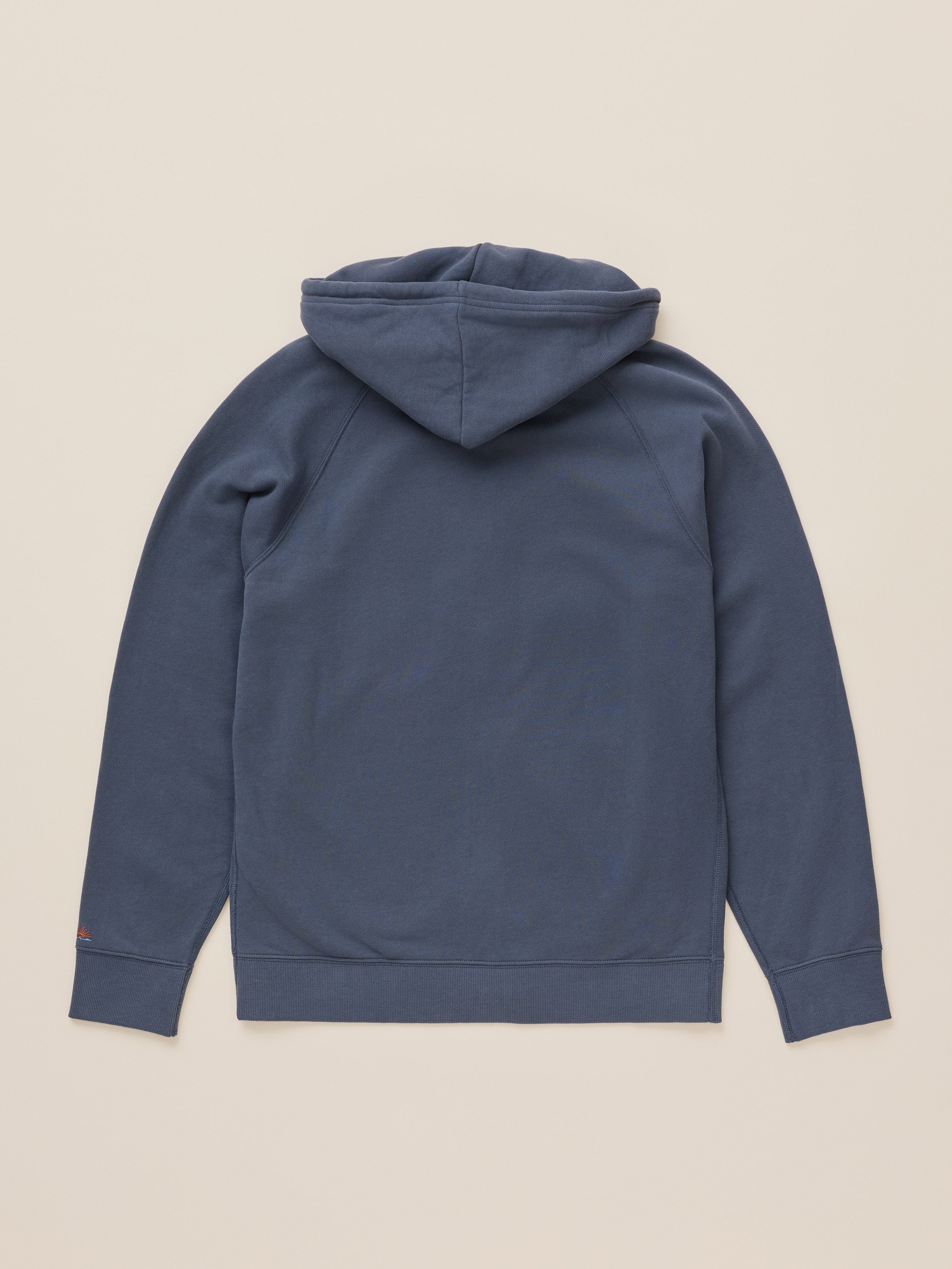 A slate blue pullover hoodie shown from the back, laid flat on a light beige background.