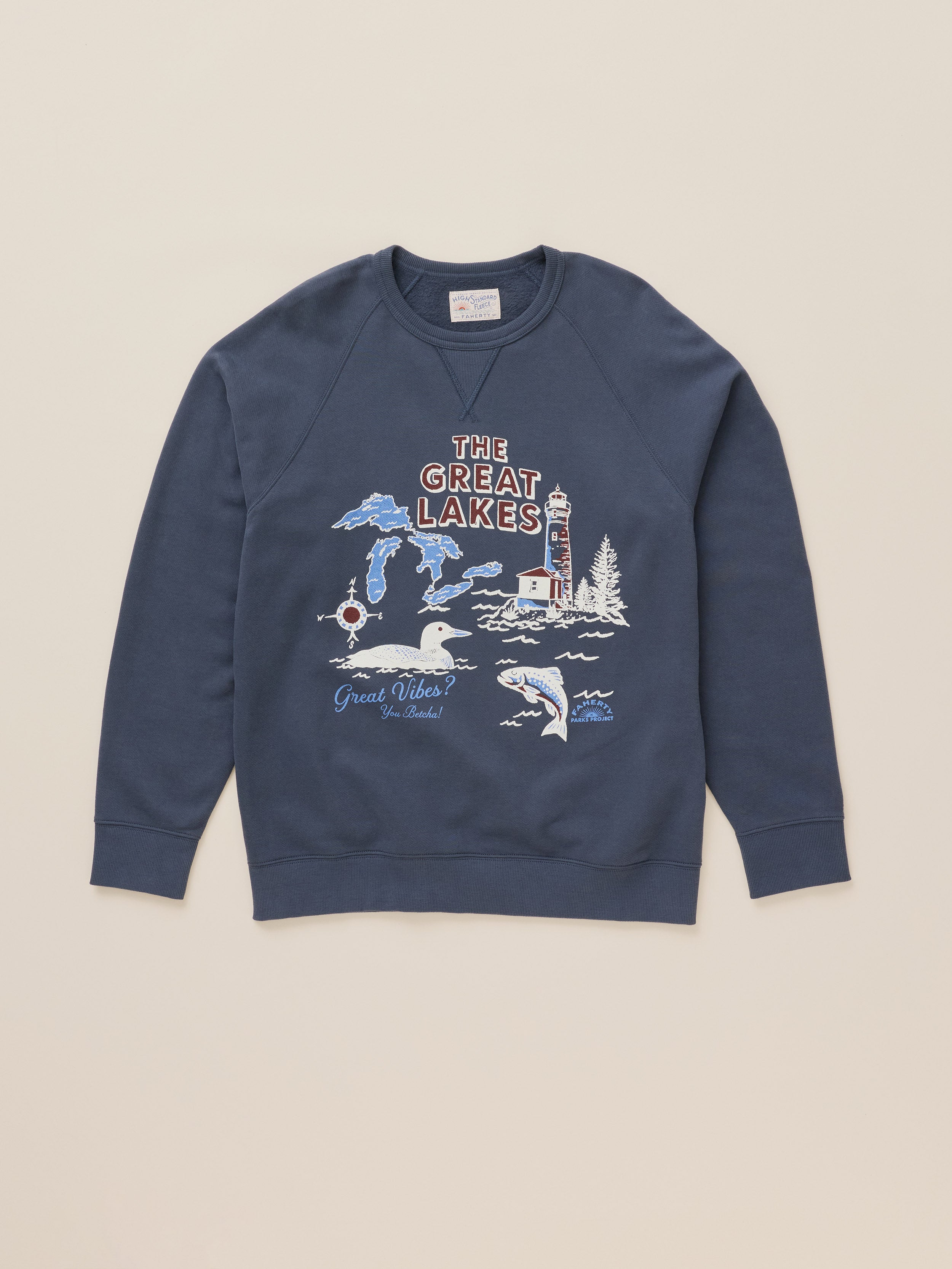 A navy blue crewneck sweatshirt featuring a 'The Great Lakes' graphic print on the front, laid flat against a light beige background.