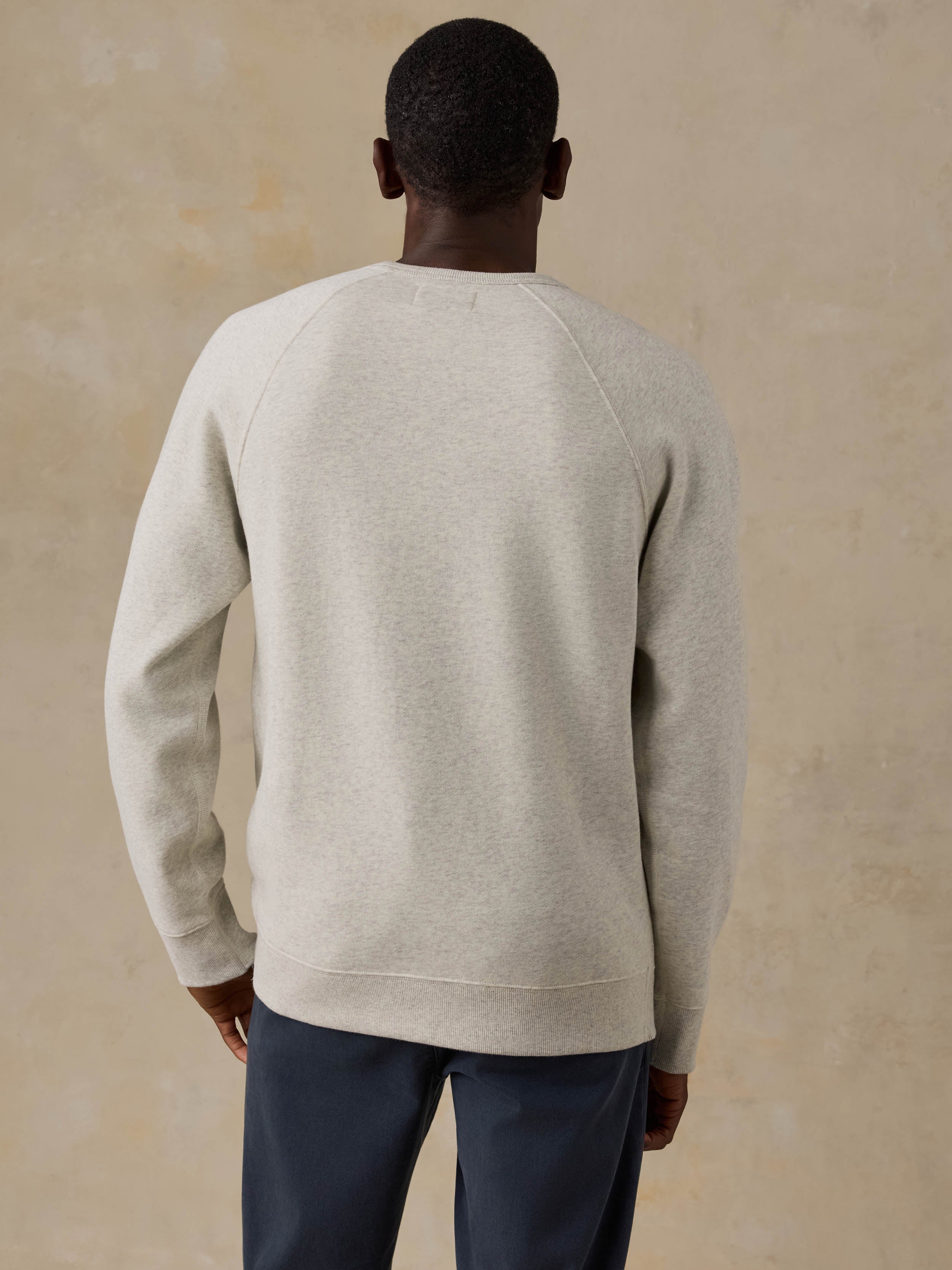 Man wearing a gray sweatshirt on a beige background
