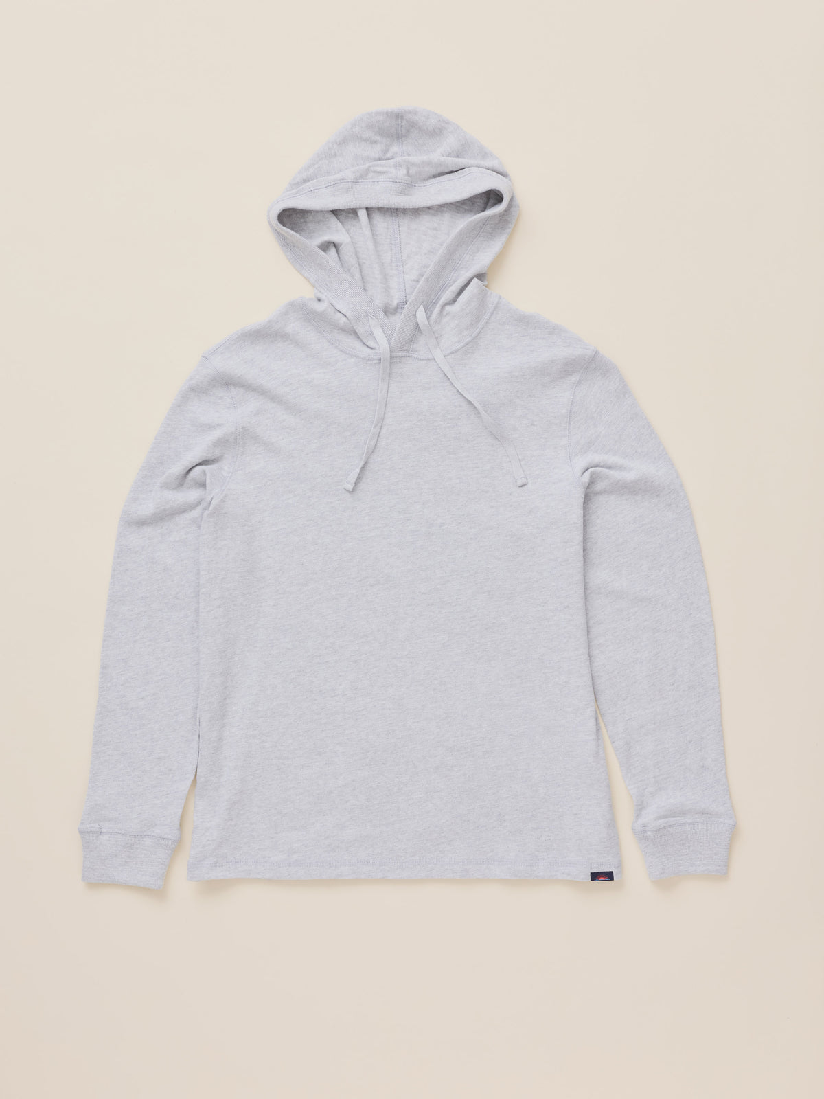 A light gray heather pullover hoodie with drawstrings, laid flat against a solid beige background., image 7 of 8