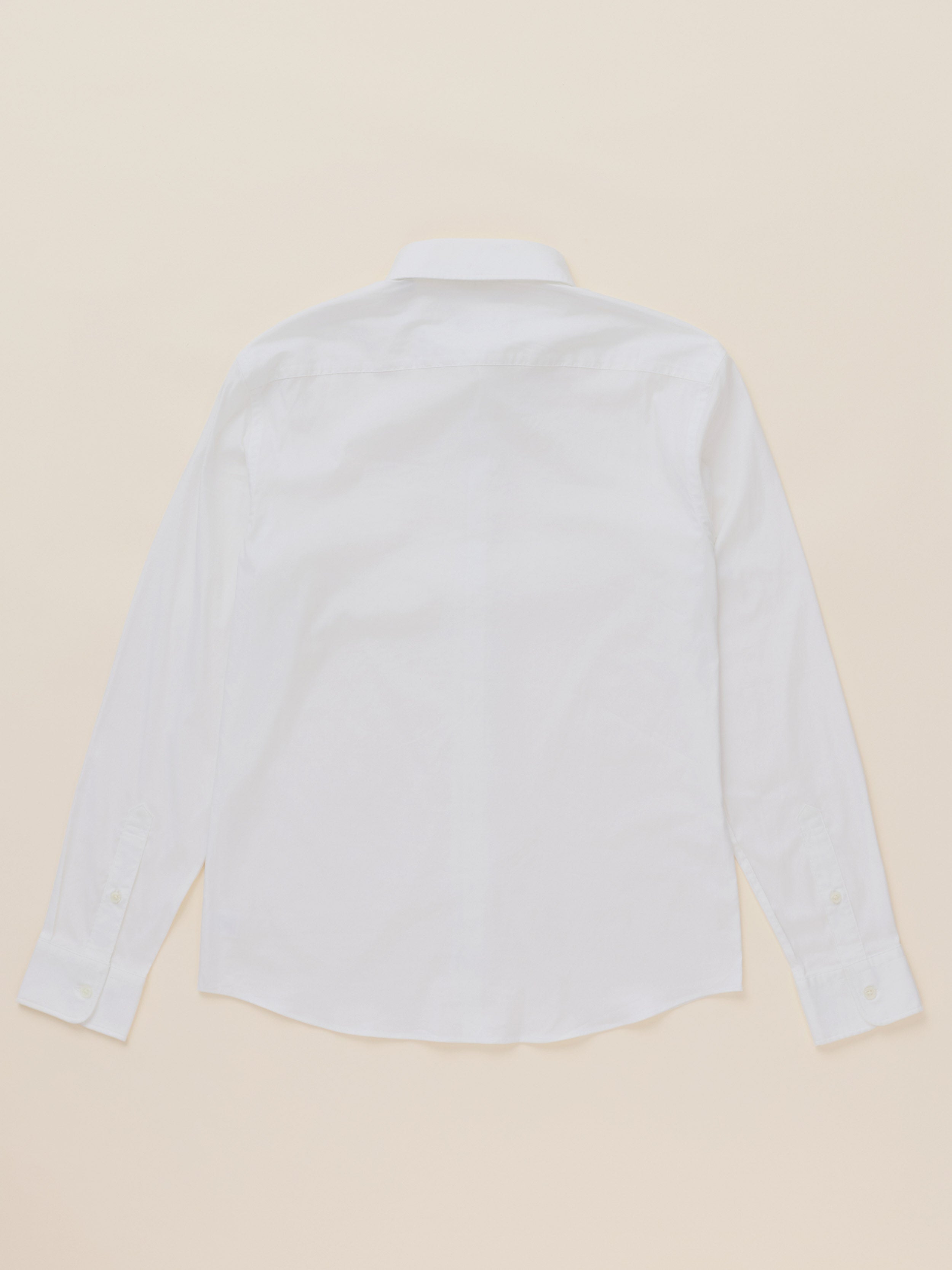 A white long-sleeve button-down shirt shown from the back, laid flat on a light beige background.