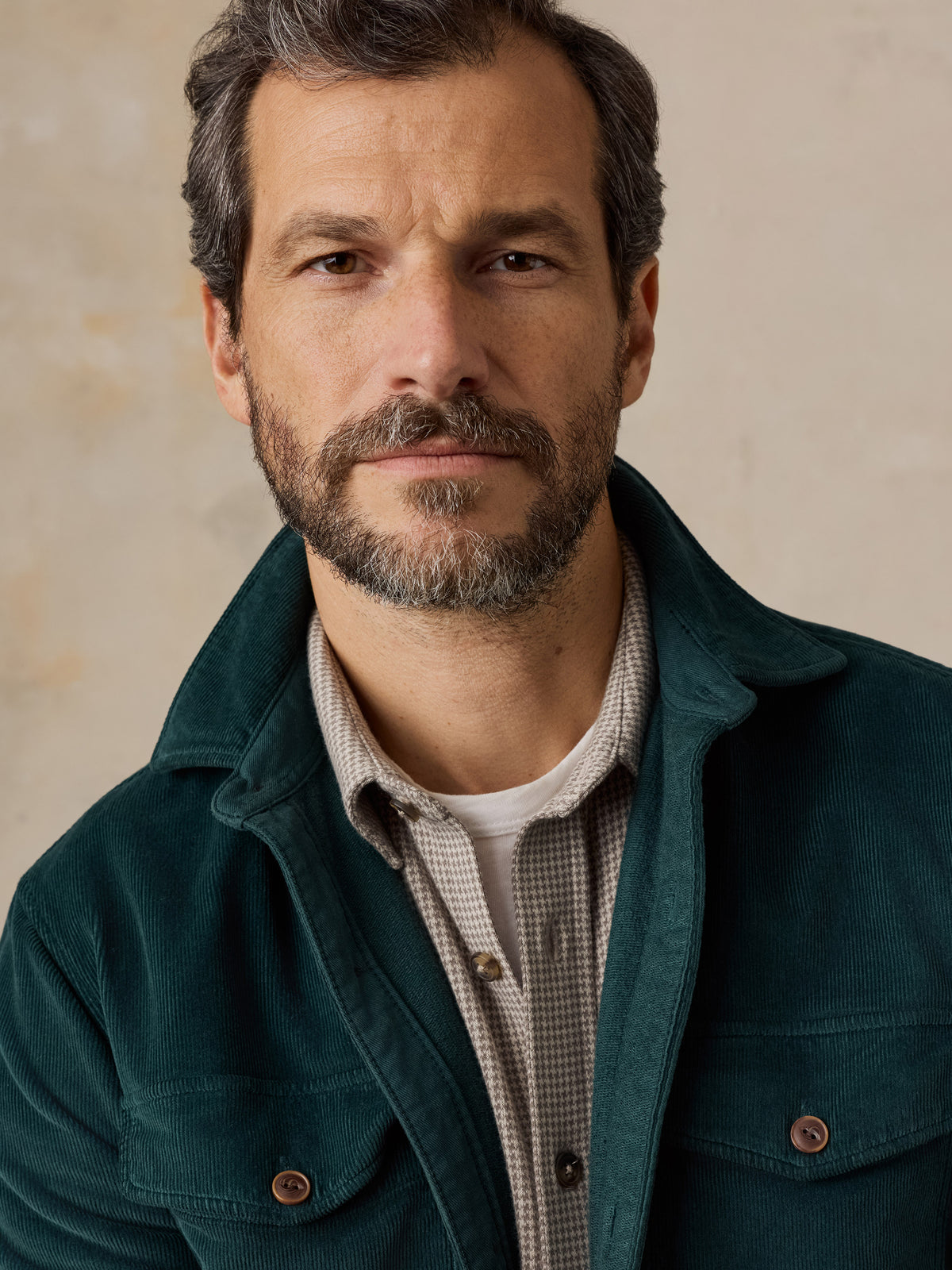 Close up of a man wearing a green overshirt with a beige checkered shirt, image 3 of 5