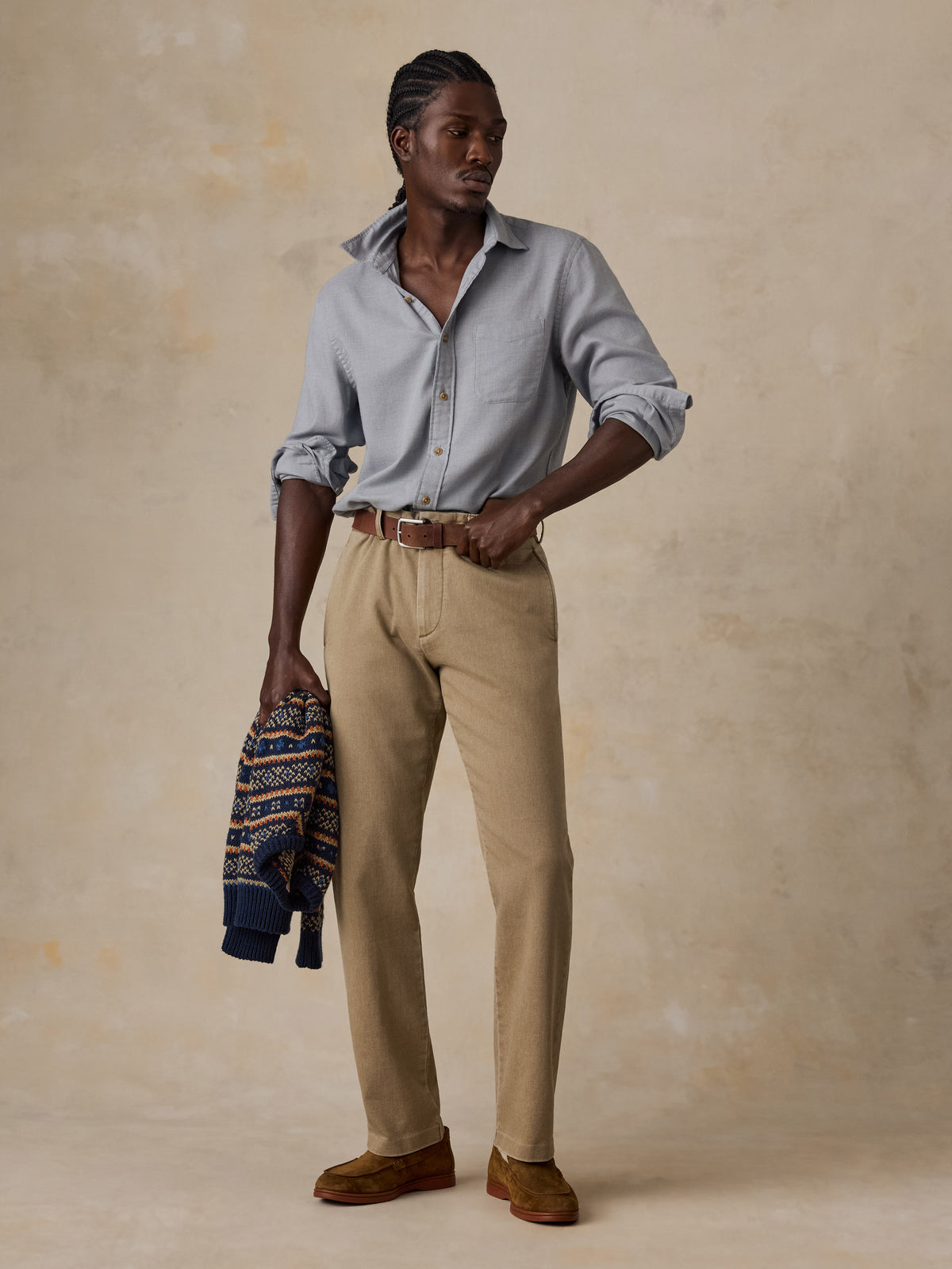 A man wearing a grey shirt and beige pants, image 2 of 5
