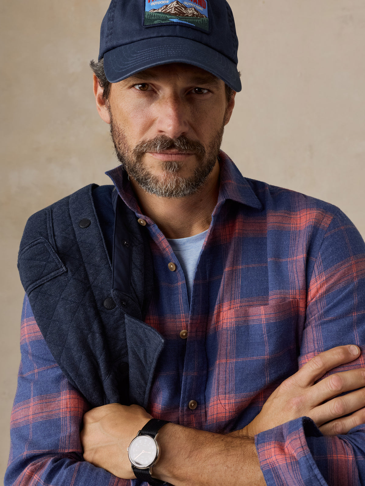 Close up of a man wearing a blue plaid shirt and a hat, image 3 of 5