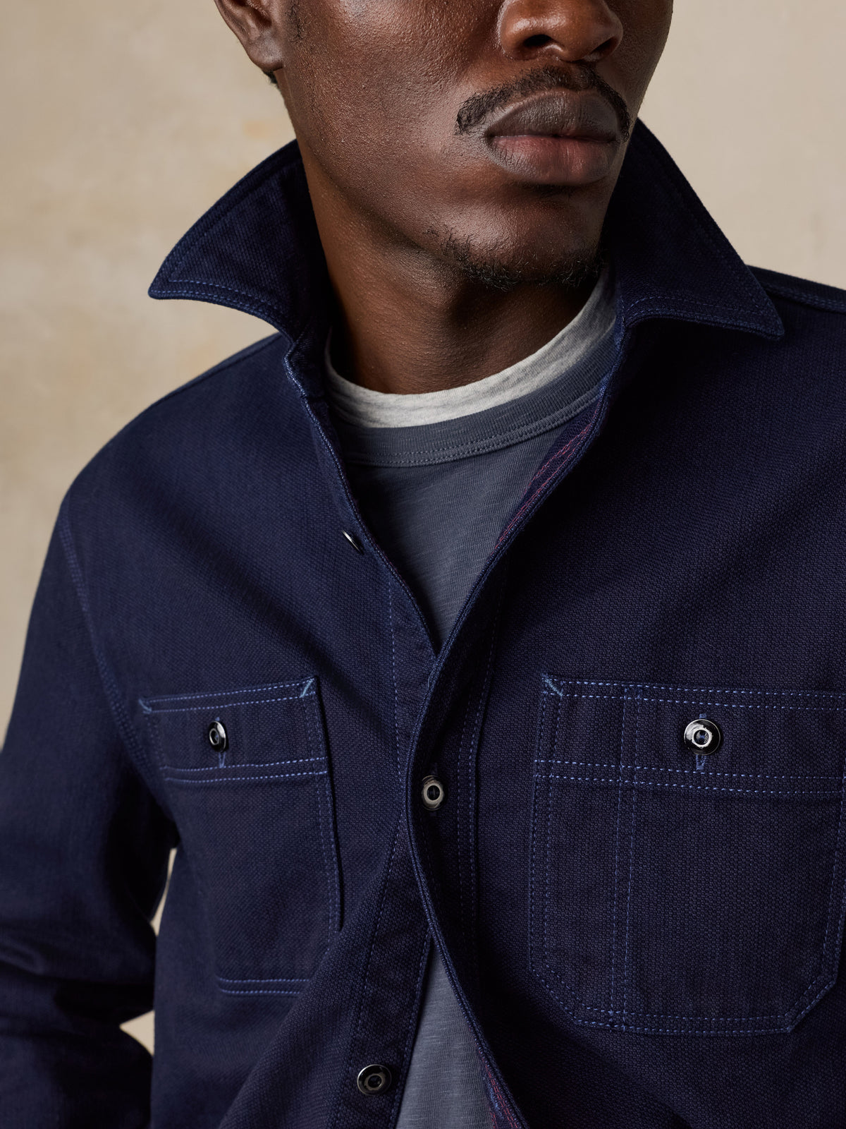 Close up of a man wearing a blue workshirt over a blue tee, image 3 of 6