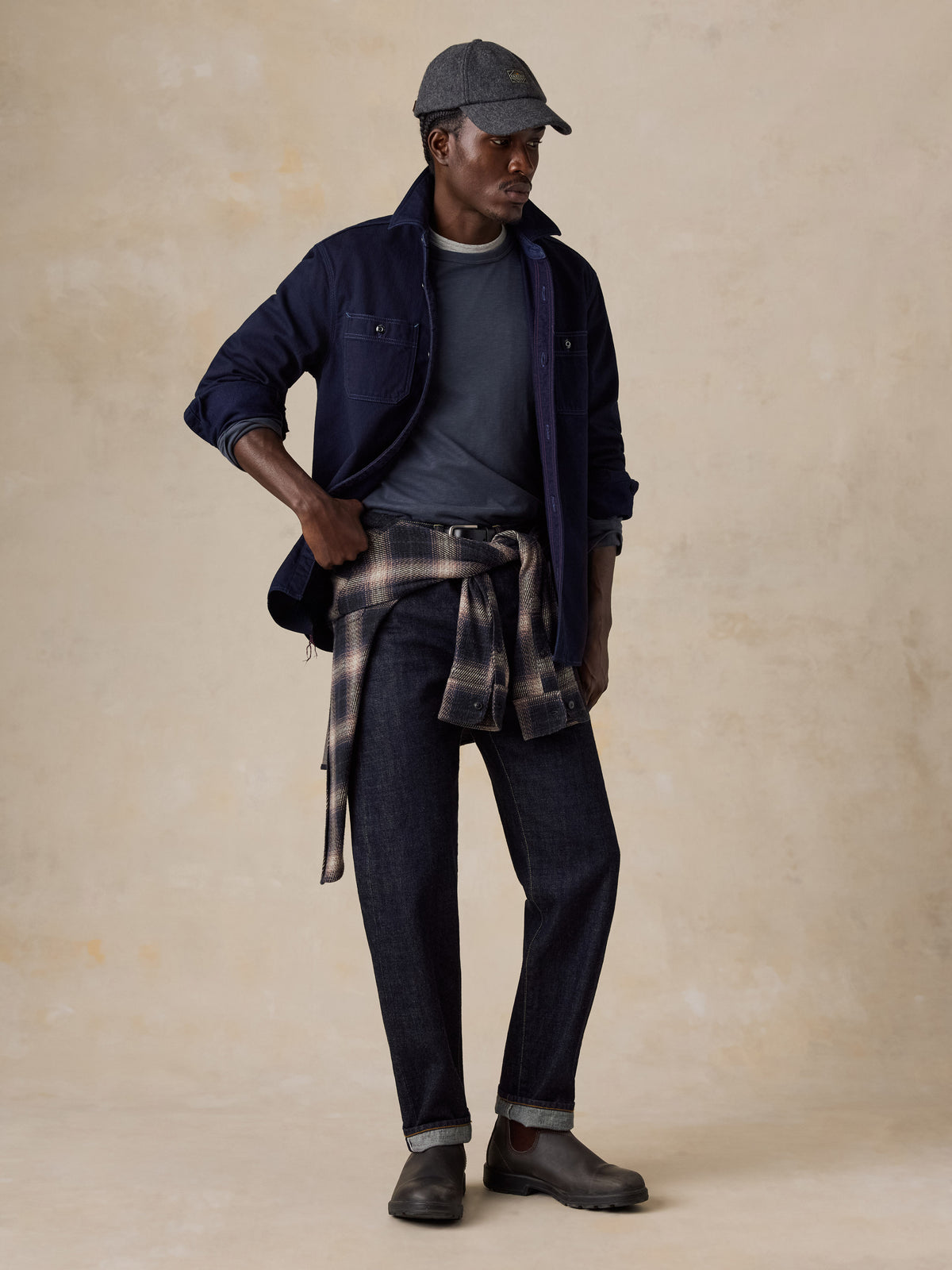 A man wearing a blue workshirt over a blue tee and blue jeans, image 2 of 6