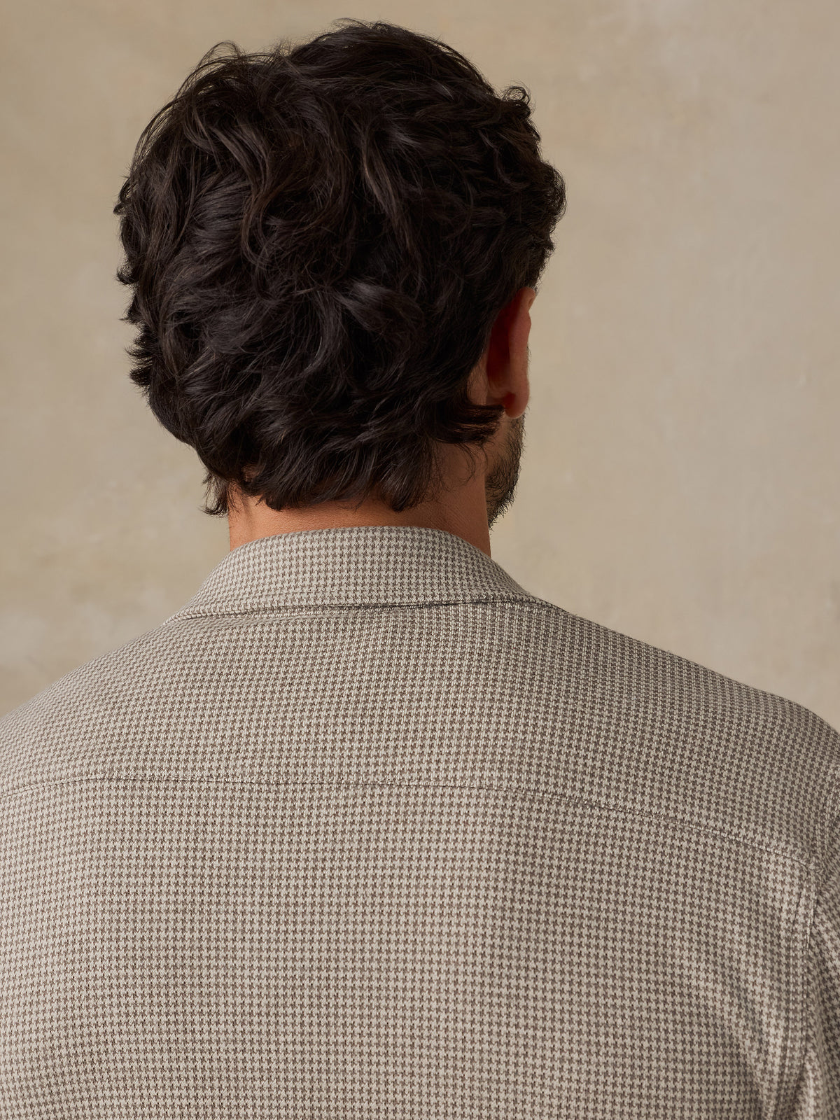Man wearing a beige overshirt against a beige studio background, image 6 of 7