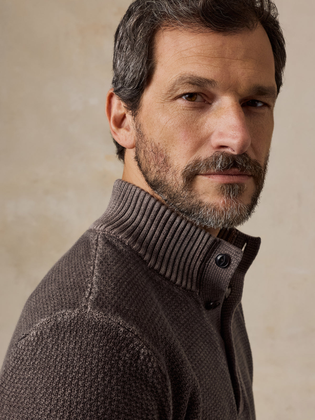 Close up of a man wearing a brown sweater, image 5 of 5