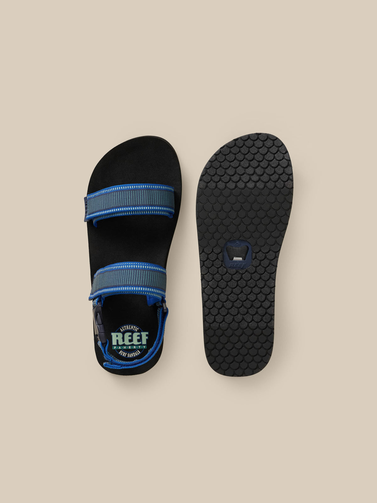 Black sandal with blue accents on a beige background, image 2 of 3