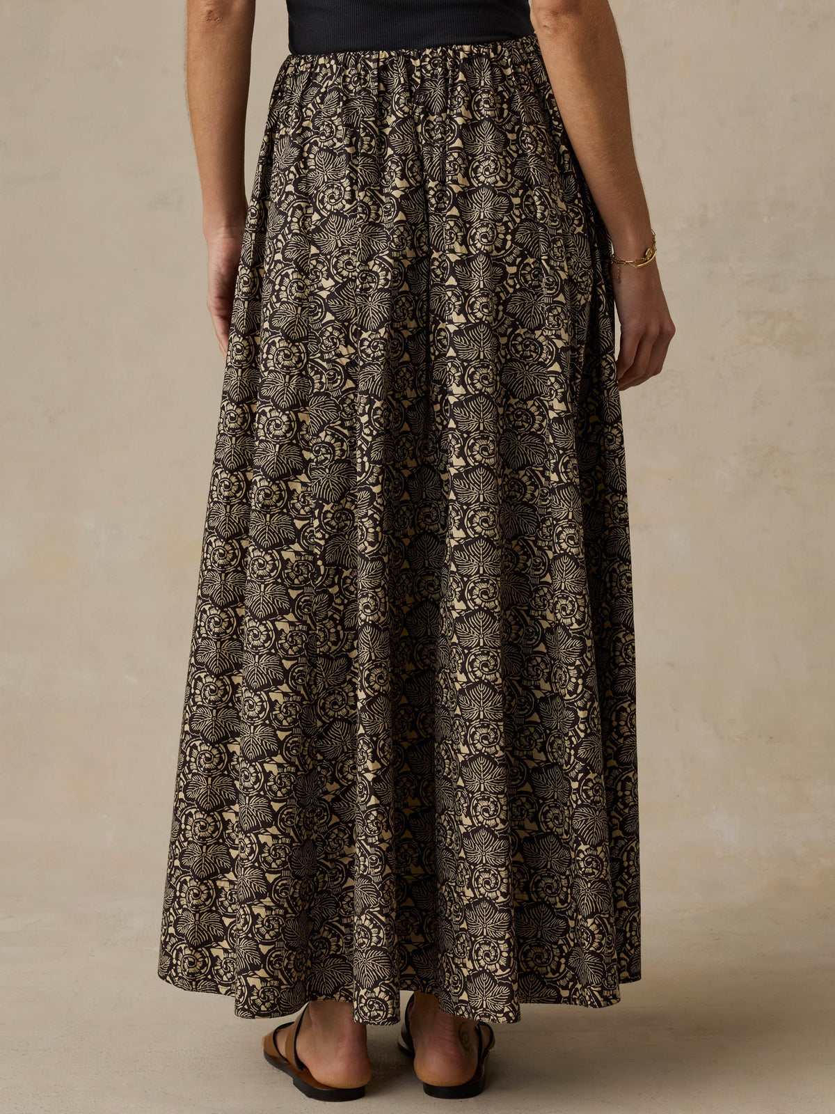 Woman wearing a floral patterned top against a beige background, image 5 of 6