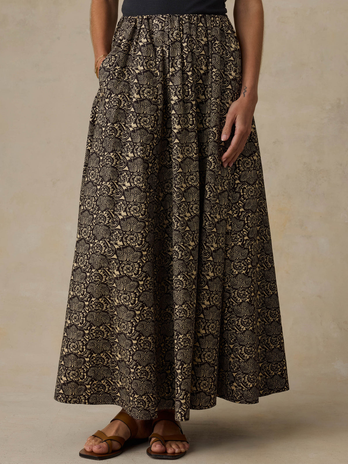 Woman wearing a floral patterned skirt against a beige background, image 3 of 6