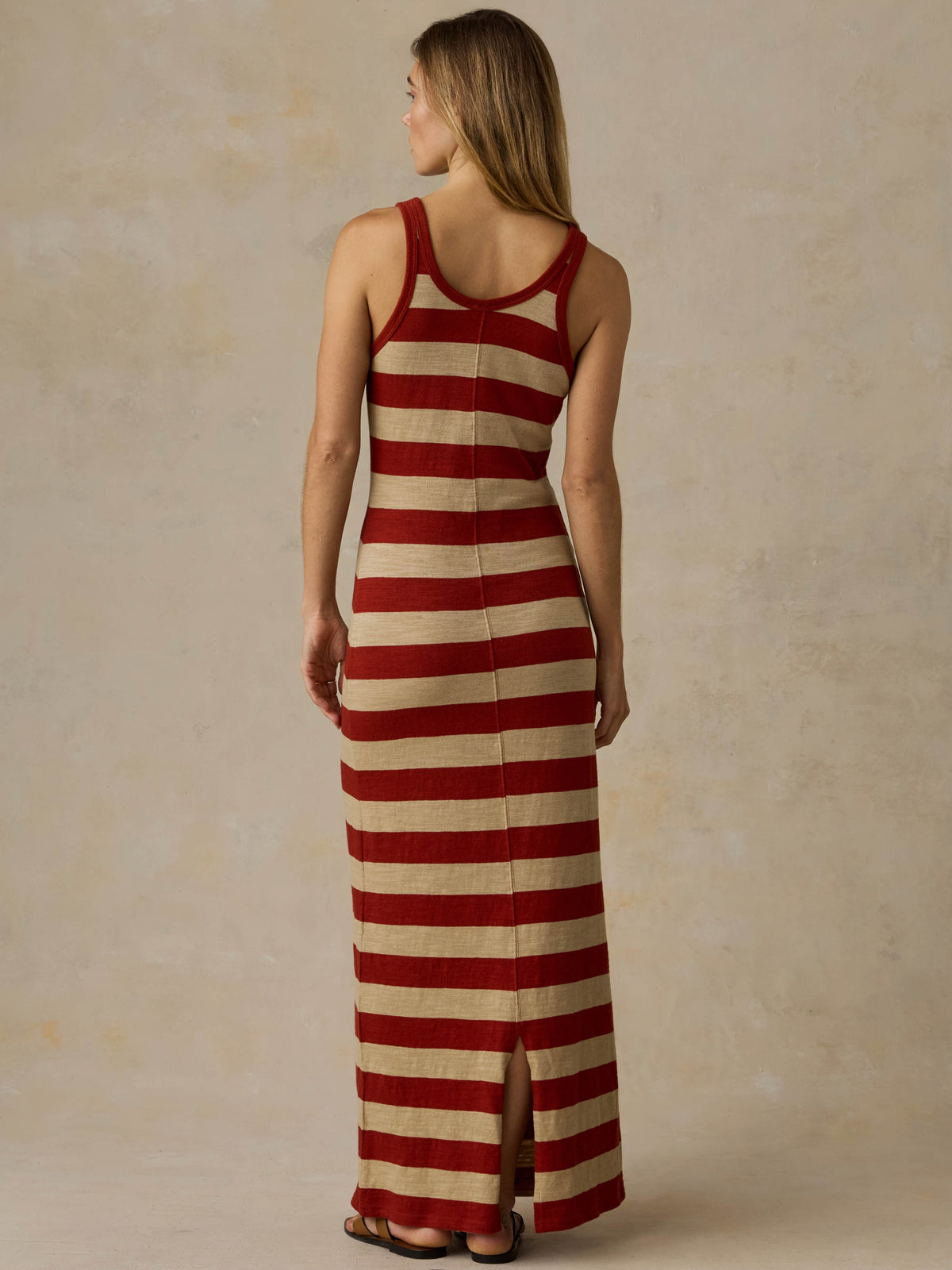 Woman wearing a red and beige striped dress against a beige background, image 4 of 6