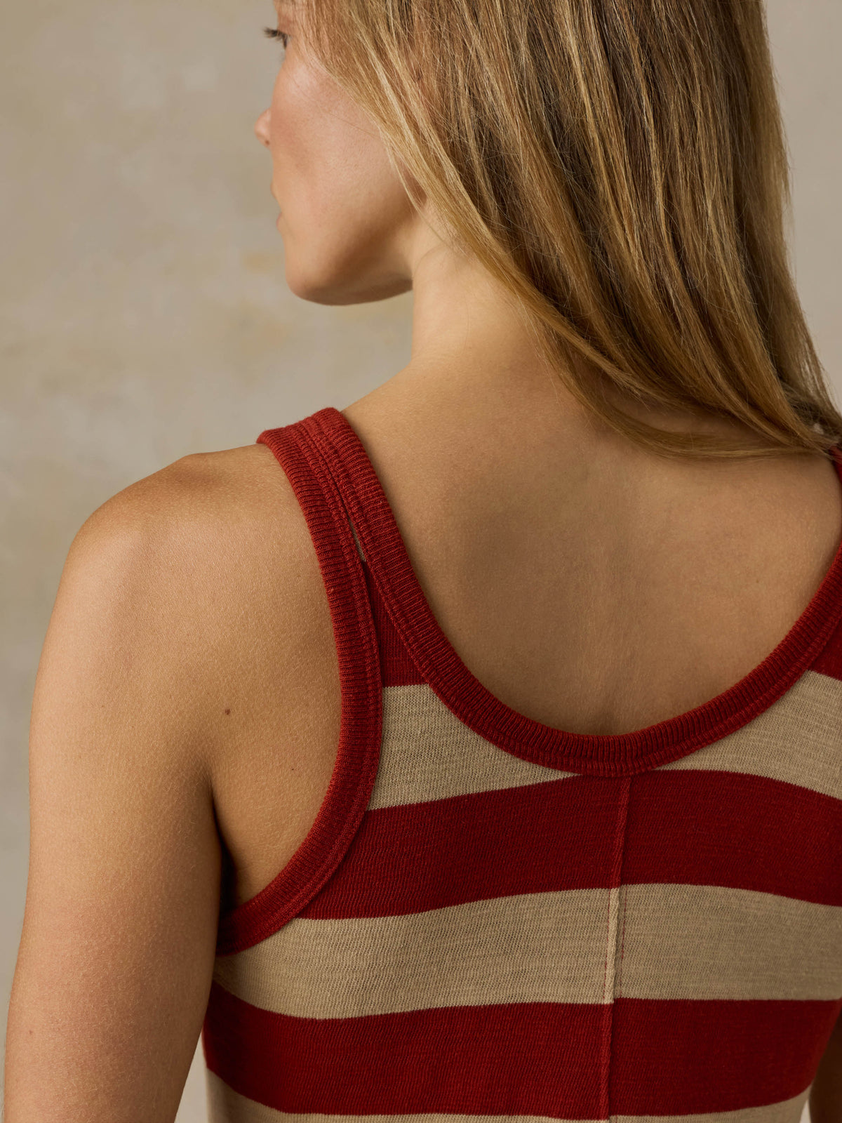 Woman wearing a red and beige striped dress against a beige background, image 6 of 6