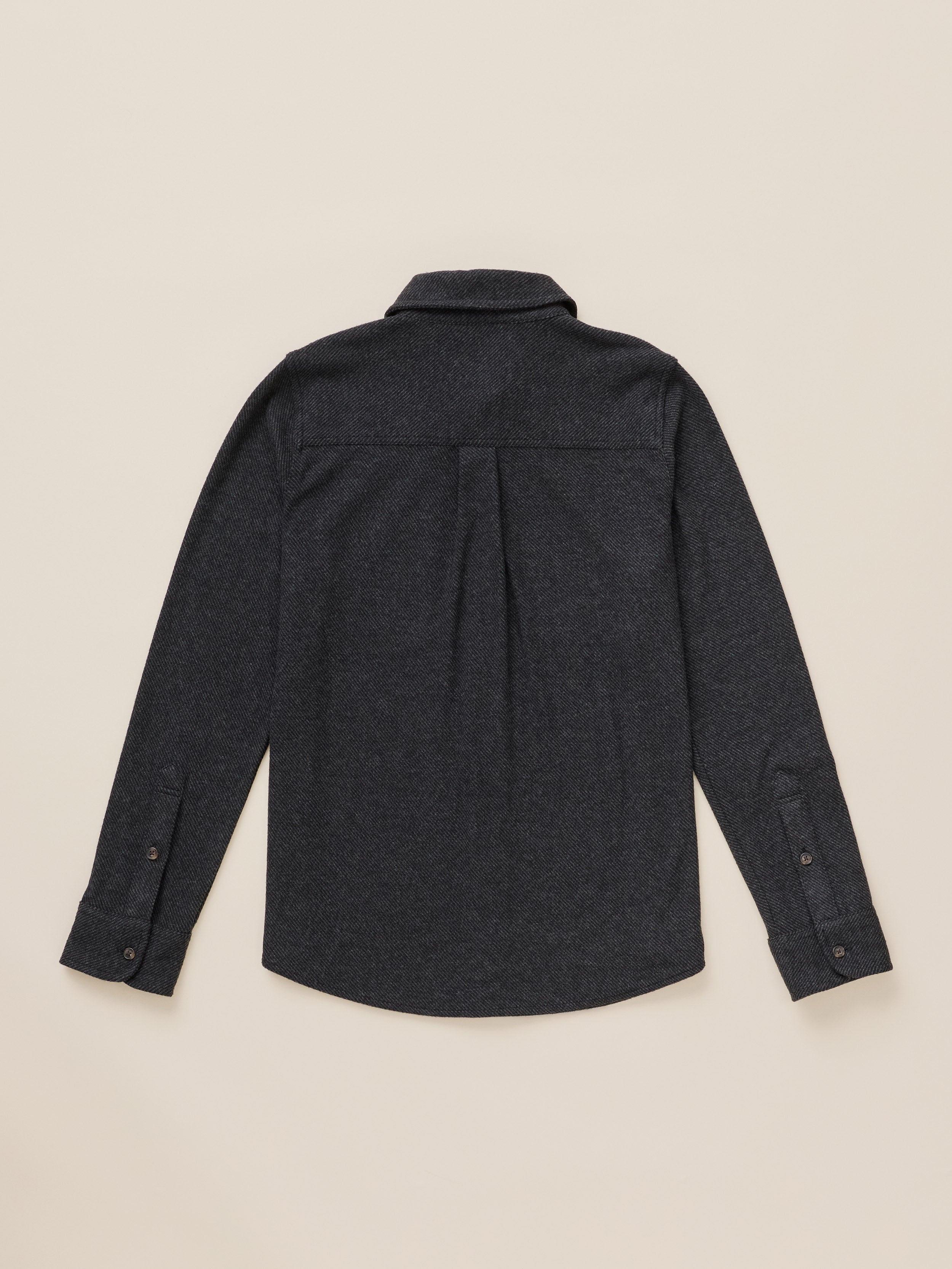 A dark charcoal gray long-sleeve button-down shirt shown from the back, laid flat on a light beige background.