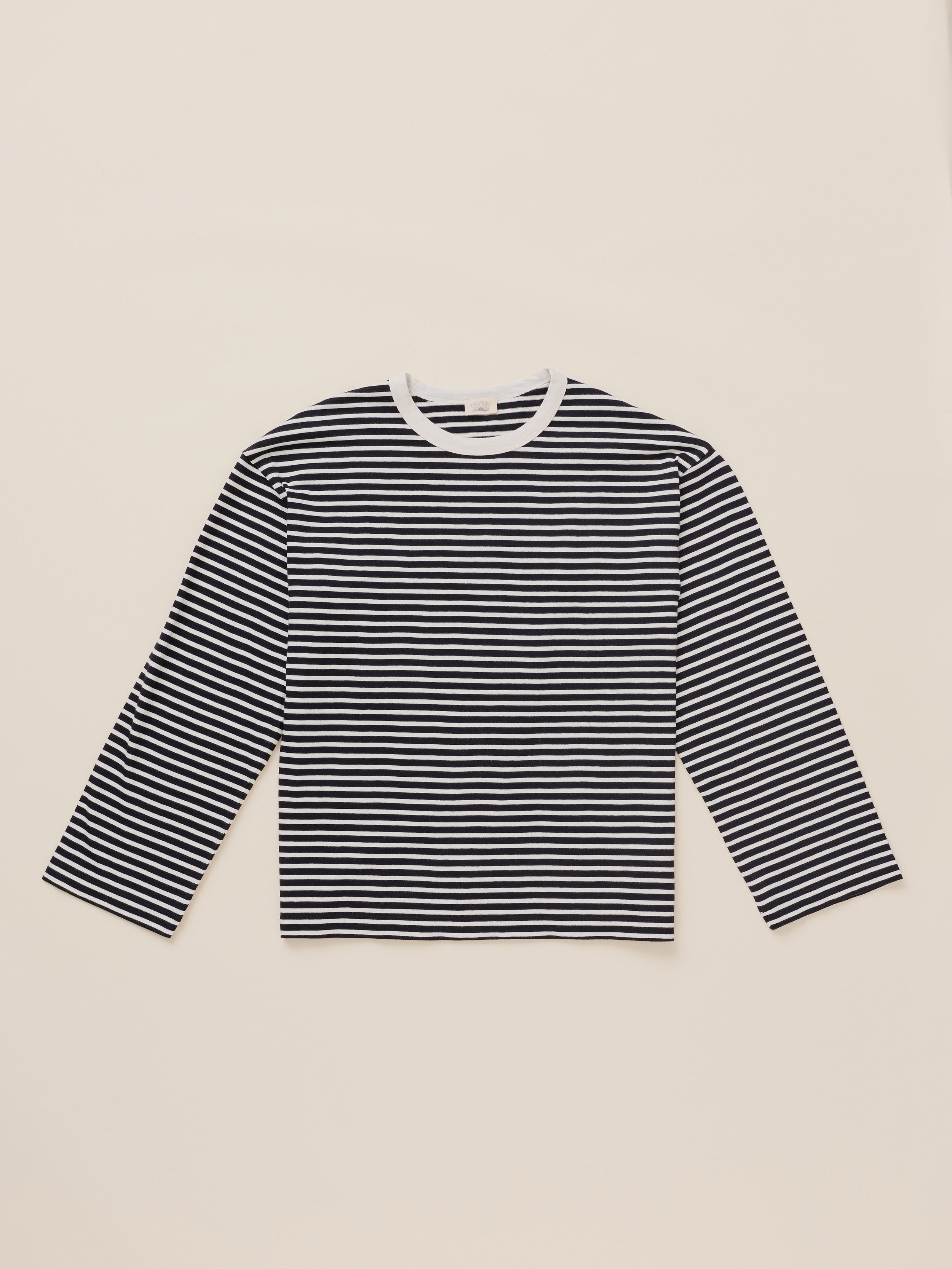 A long-sleeve crewneck shirt with horizontal black and white stripes, laid flat on a light beige background.