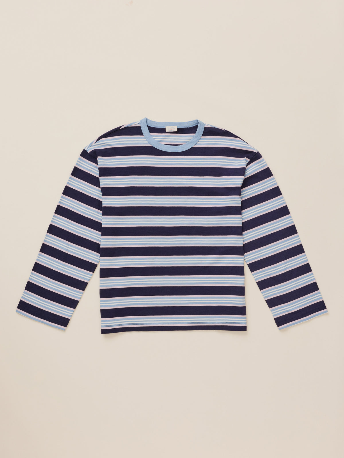 A long-sleeve crewneck shirt with horizontal navy, light blue, and white stripes, laid flat on a light beige background., image 7 of 8