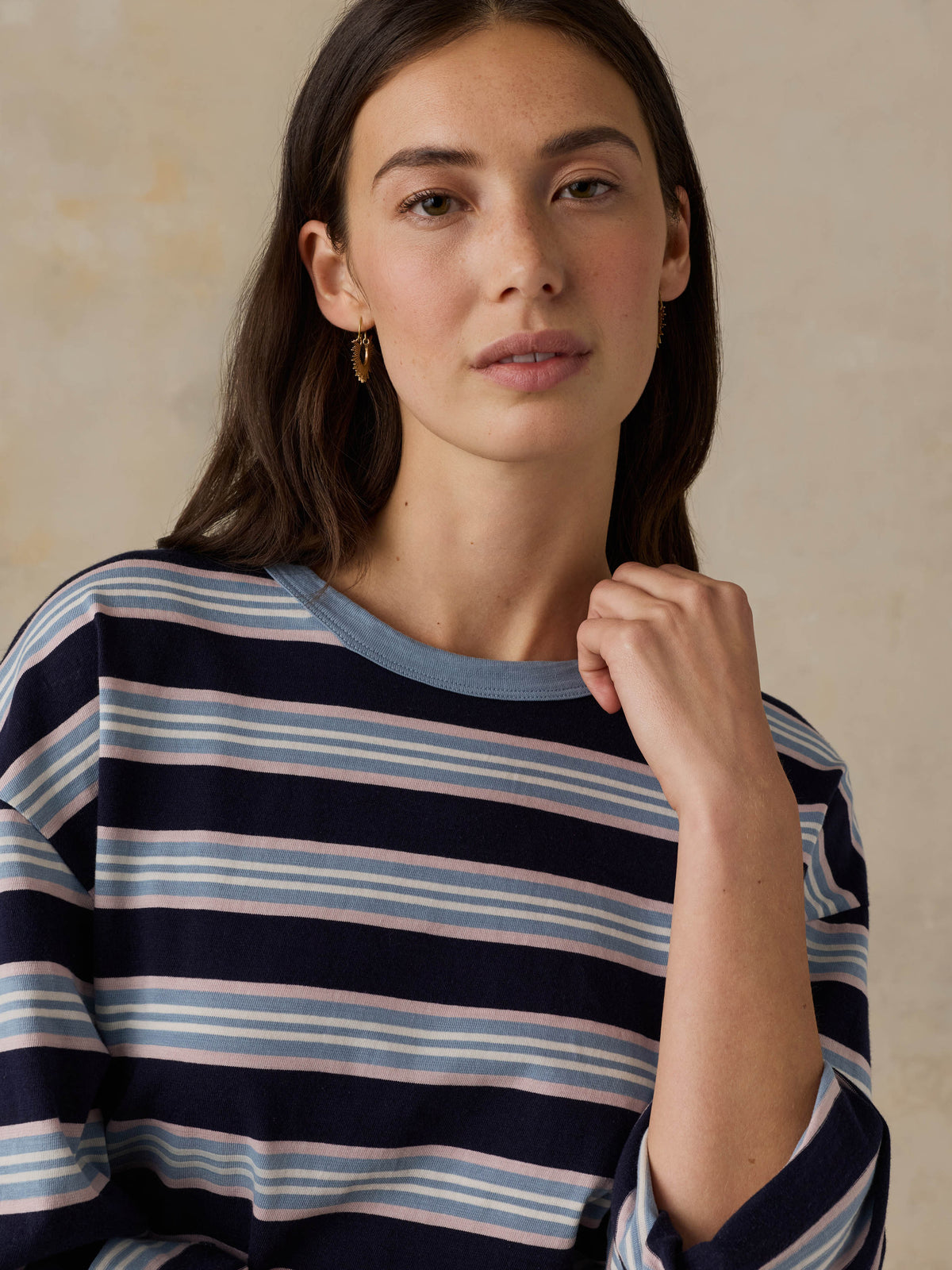 Woman wearing a blue striped shirt against a beige background, image 2 of 8