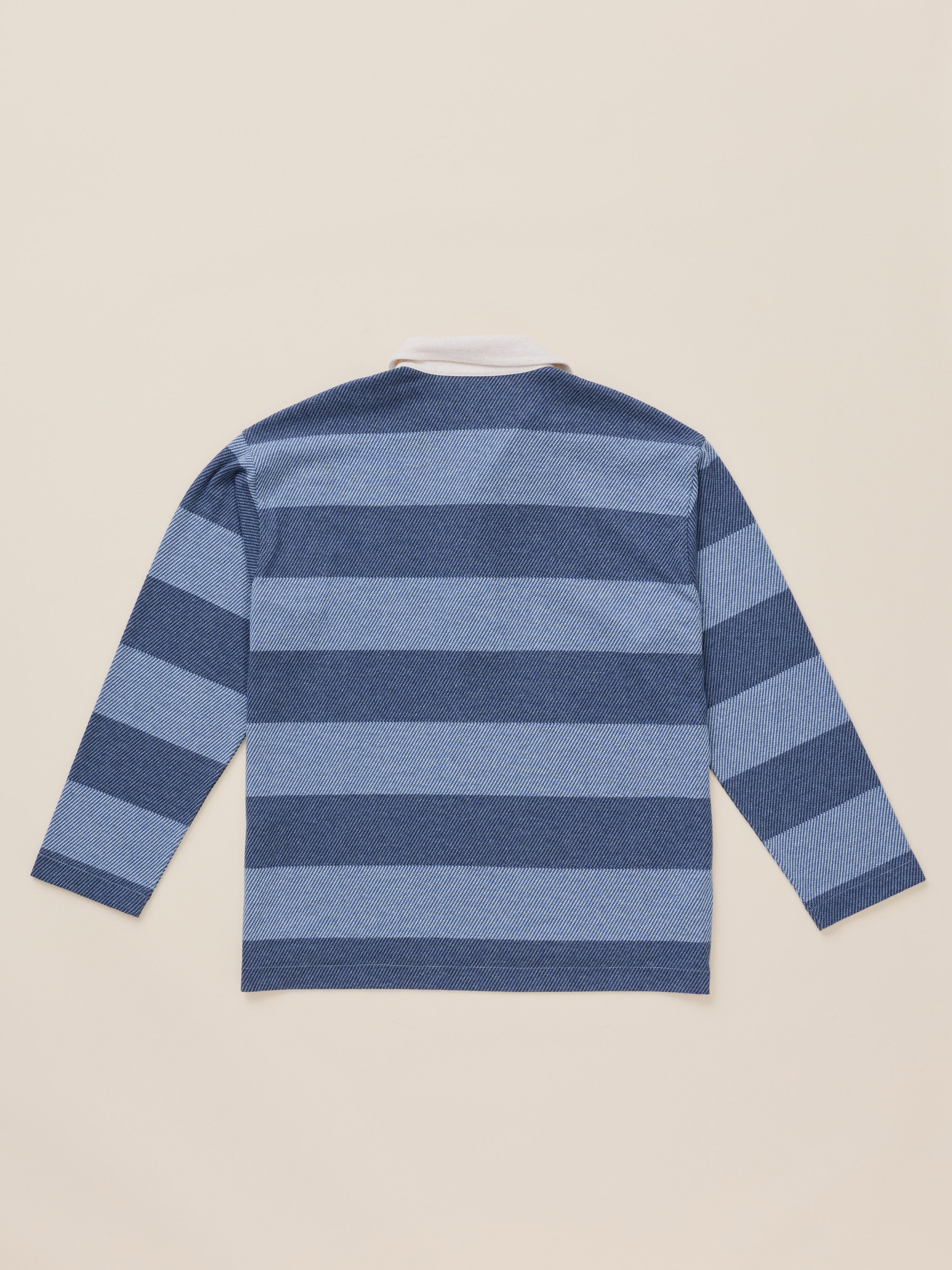 A long-sleeve striped knit top shown from the back, featuring horizontal bands of medium blue and navy blue on a light beige background.