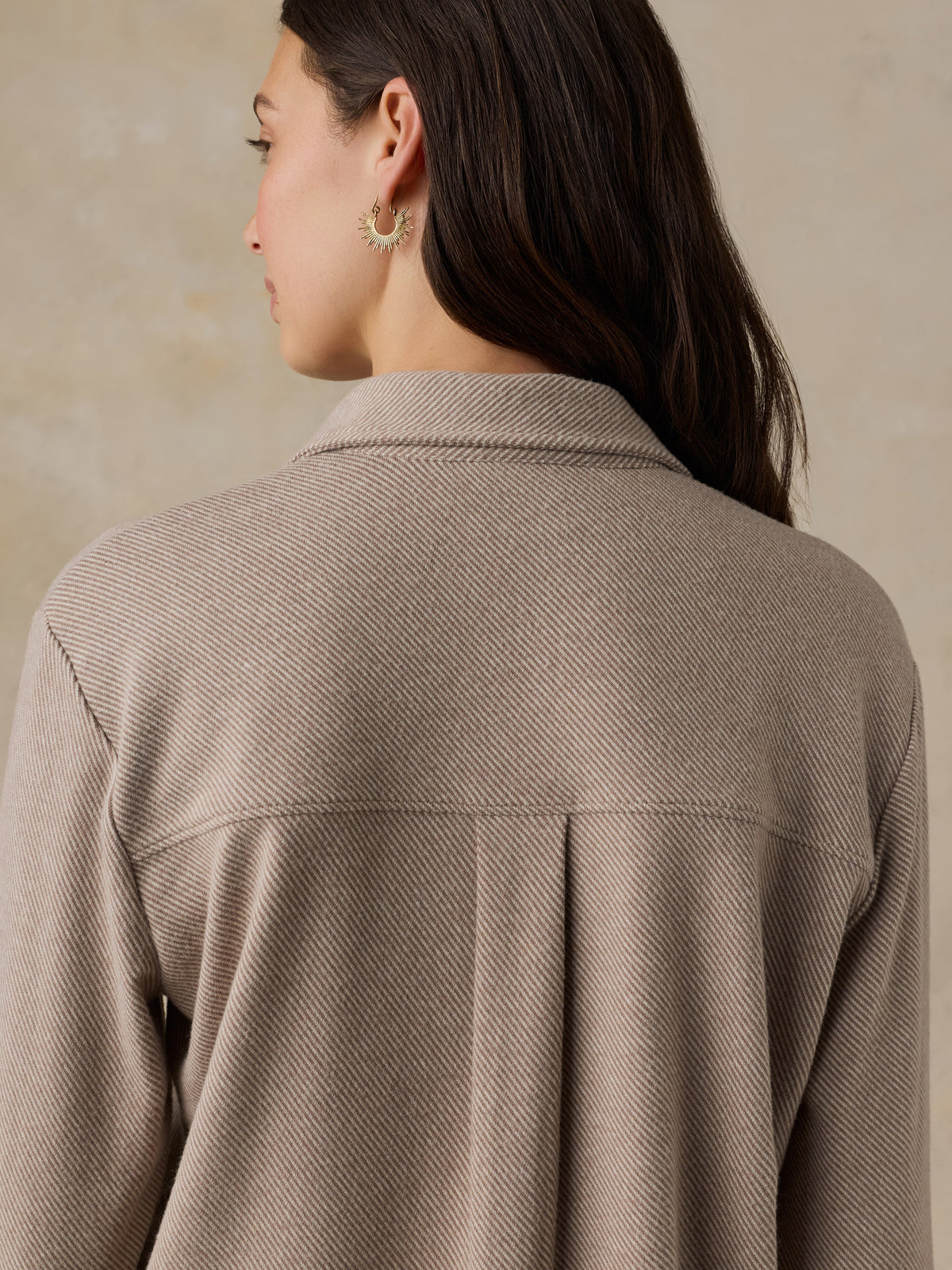 Woman wearing a beige button down shirt against a beige background, image 6 of 6
