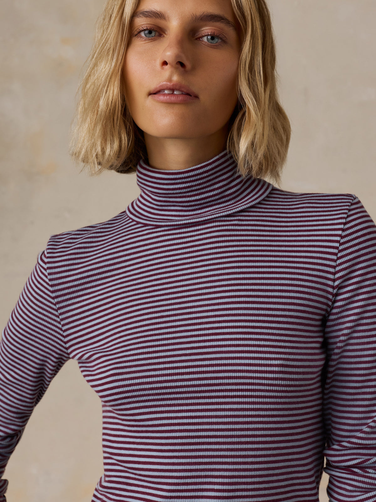 Close up of a woman wearing a blue striped turtleneck, image 6 of 6