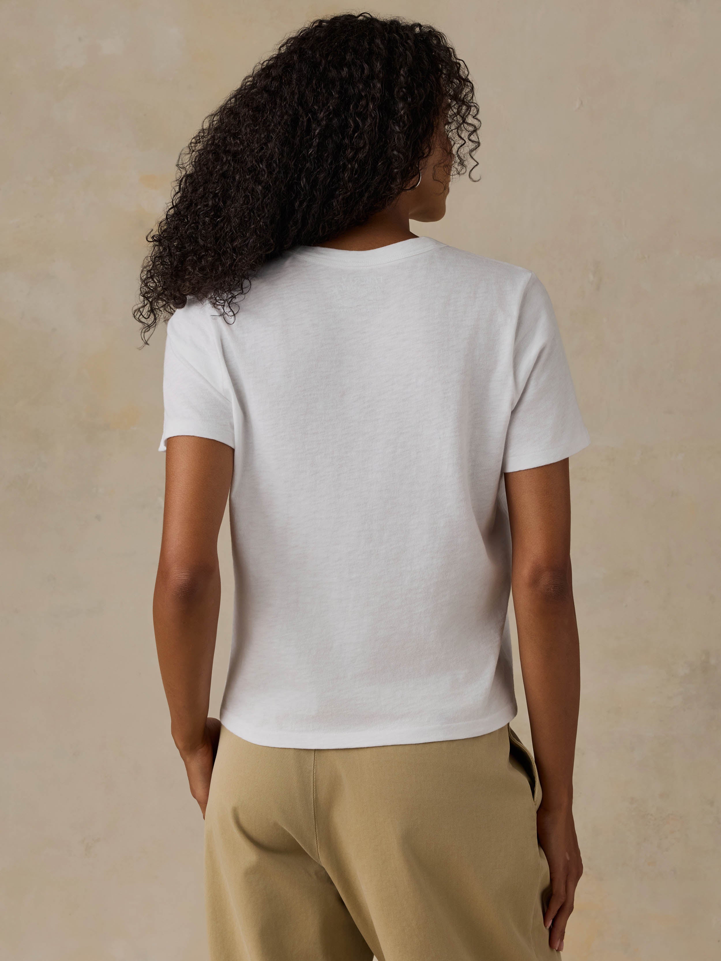 Woman wearing a white t-shirt on a beige background