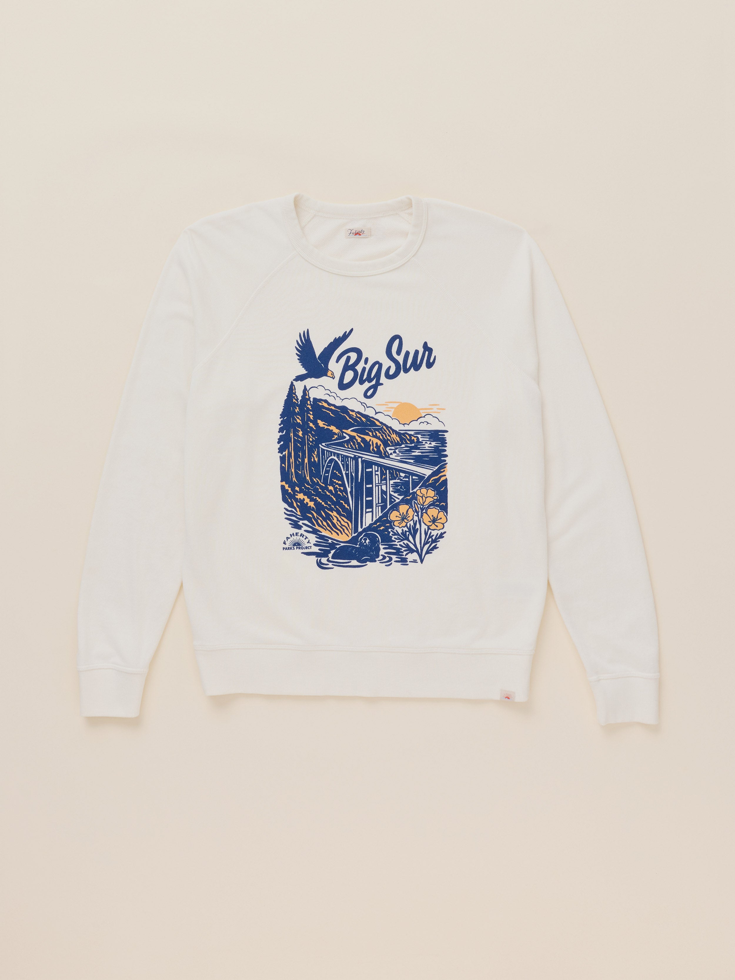An off-white crewneck sweatshirt featuring a blue and yellow graphic print of a mountain scene with the text 'Big Sur' on the front, displayed flat against a light beige background.