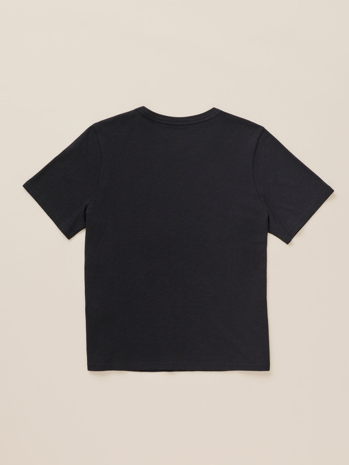 Black crewneck t-shirt against a beige background, image 7 of 7