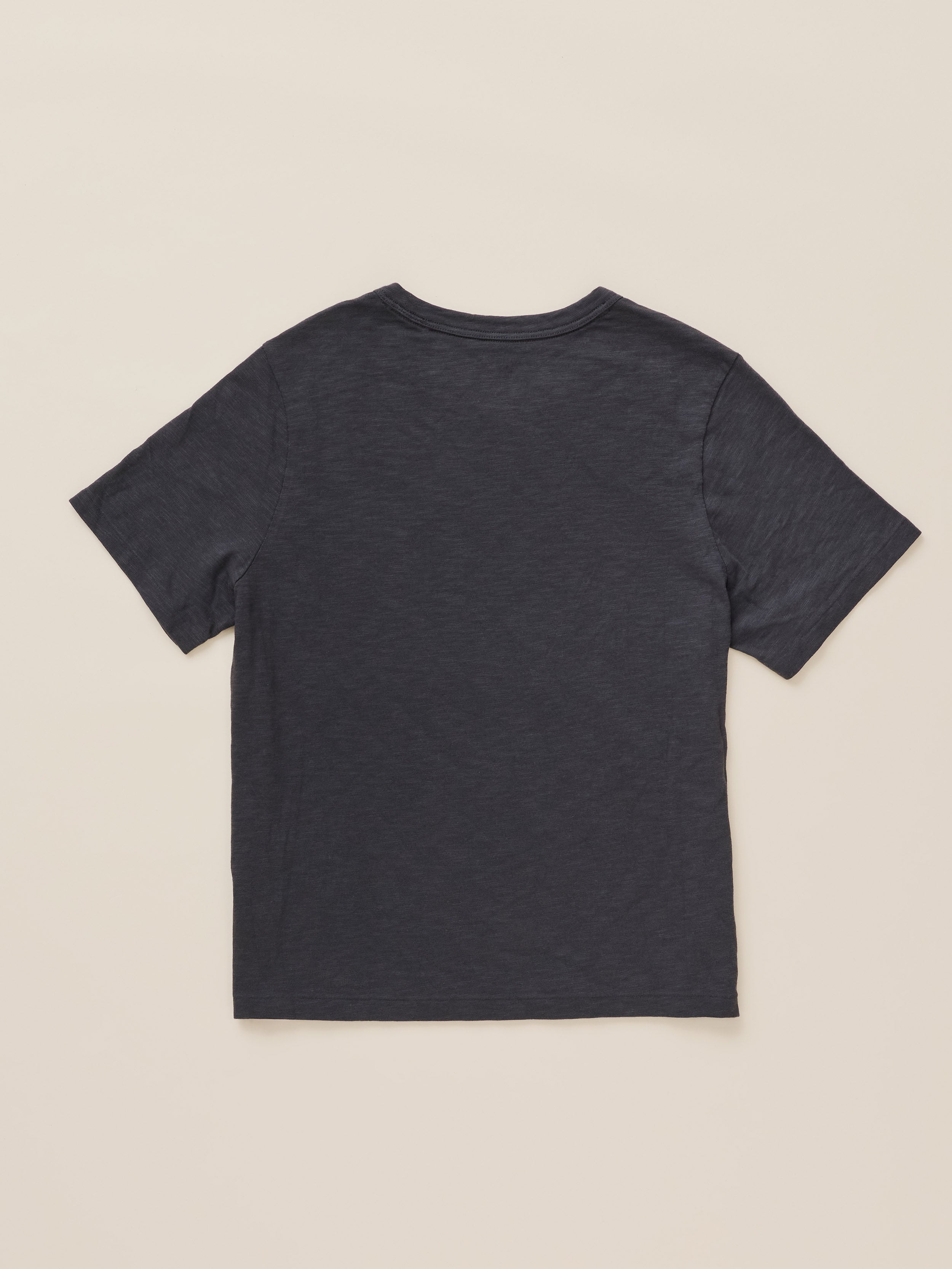 A dark charcoal gray short-sleeve t-shirt shown from the back, laid flat against a light beige background.