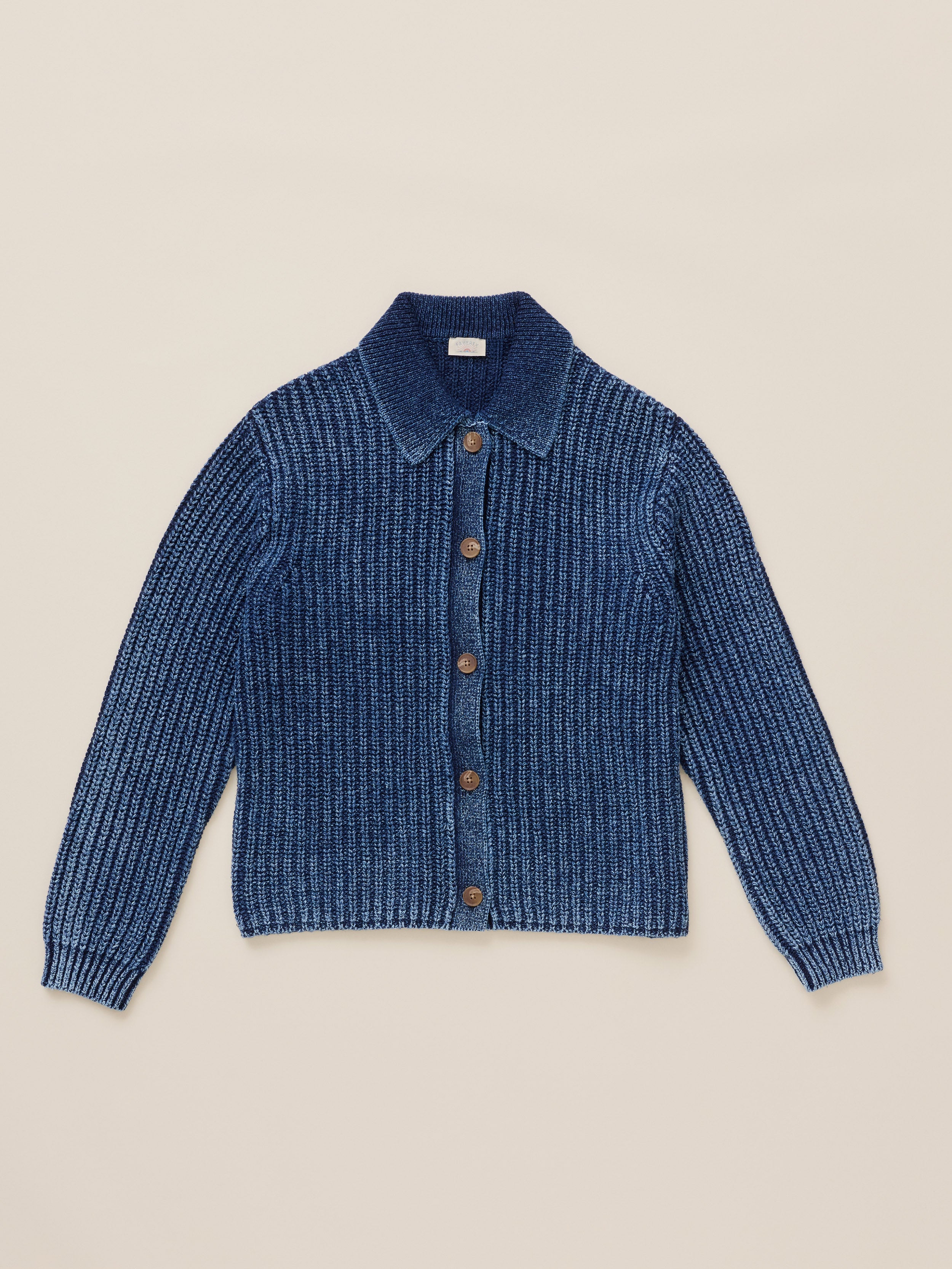 Blue cardigan against a warm beige studio background