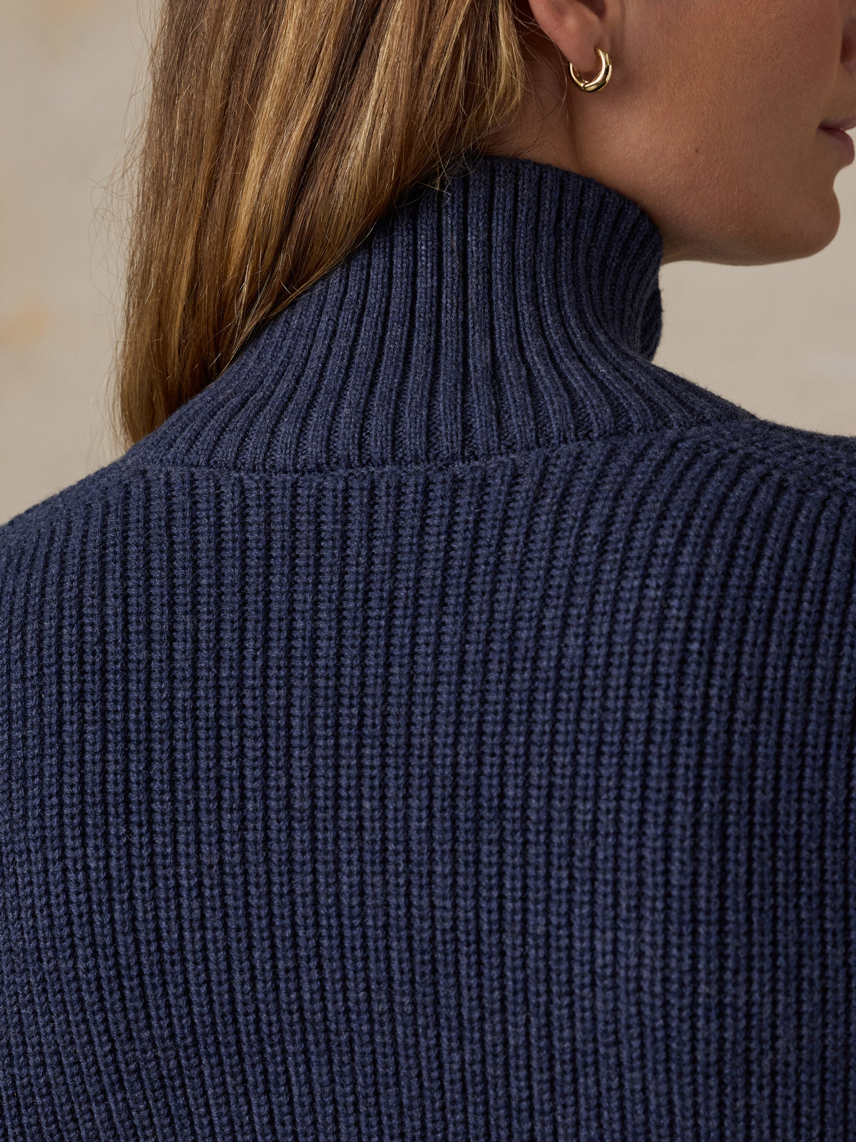 Woman wearing a navy blue quarter zip sweater , image 6 of 6