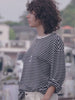 Video of a woman wearing a black and white striped shirt
